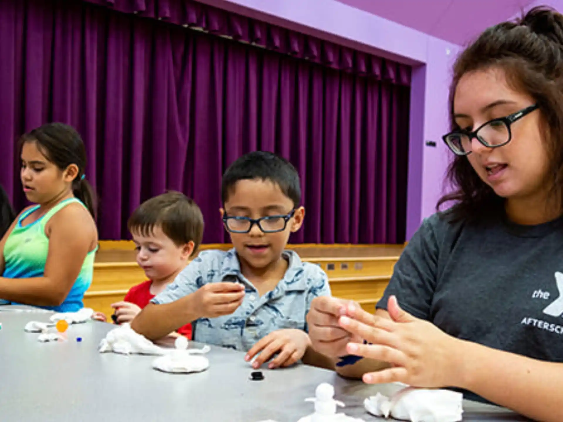 a woman and a couple of children sitting at a table