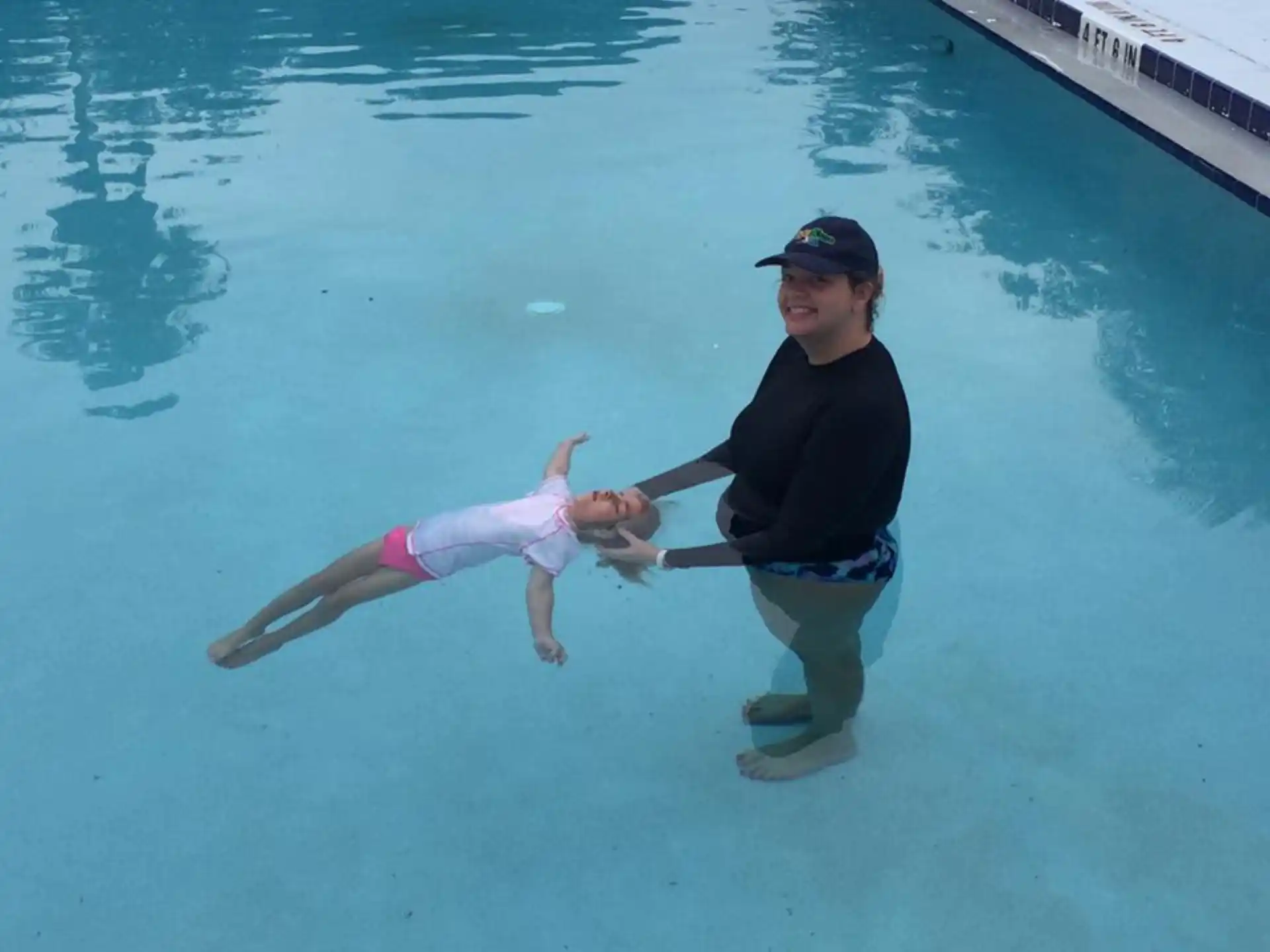 a man and a woman in a pool with a fish