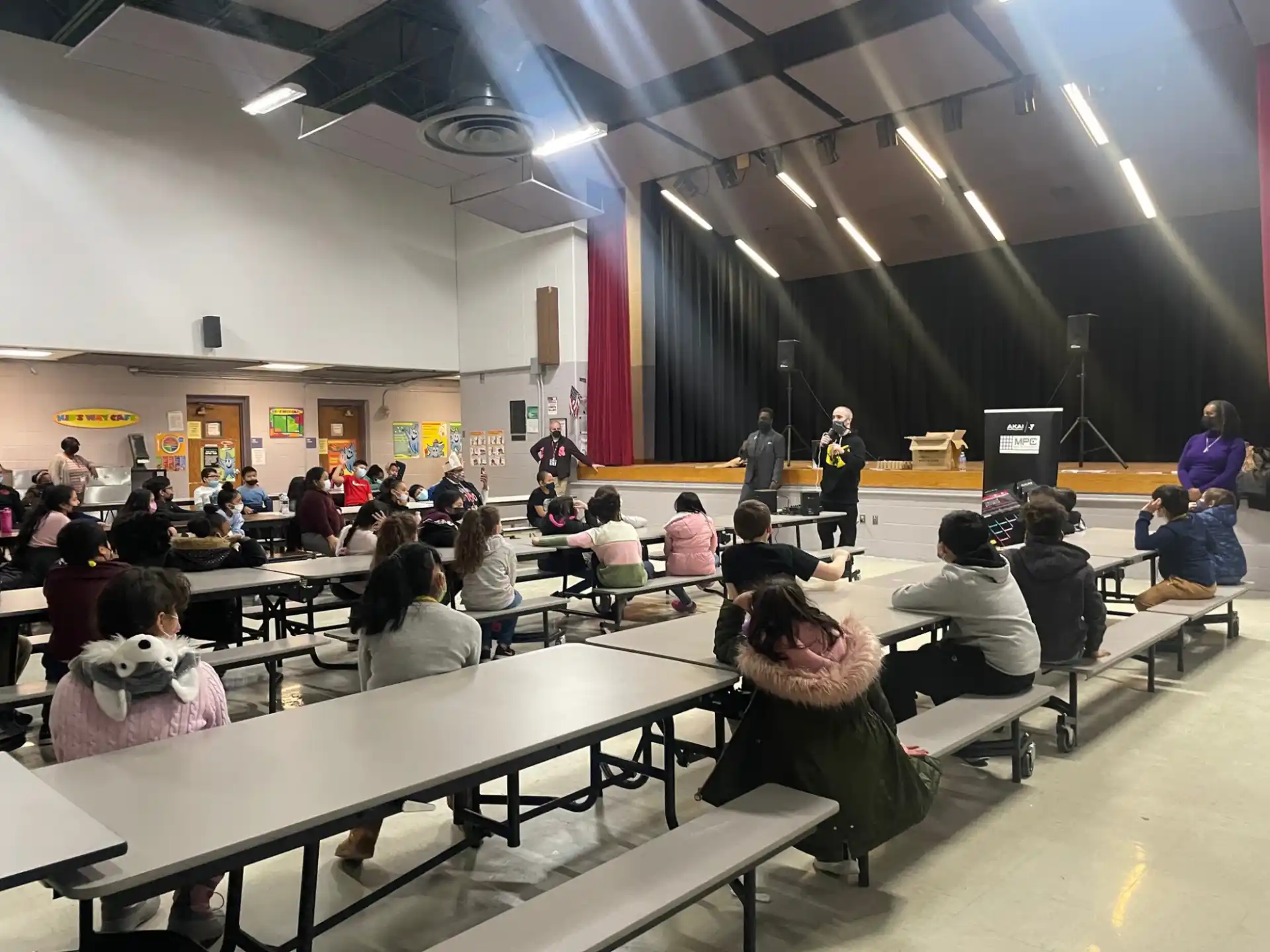 a group of people sitting in a room with tables and people in the front
