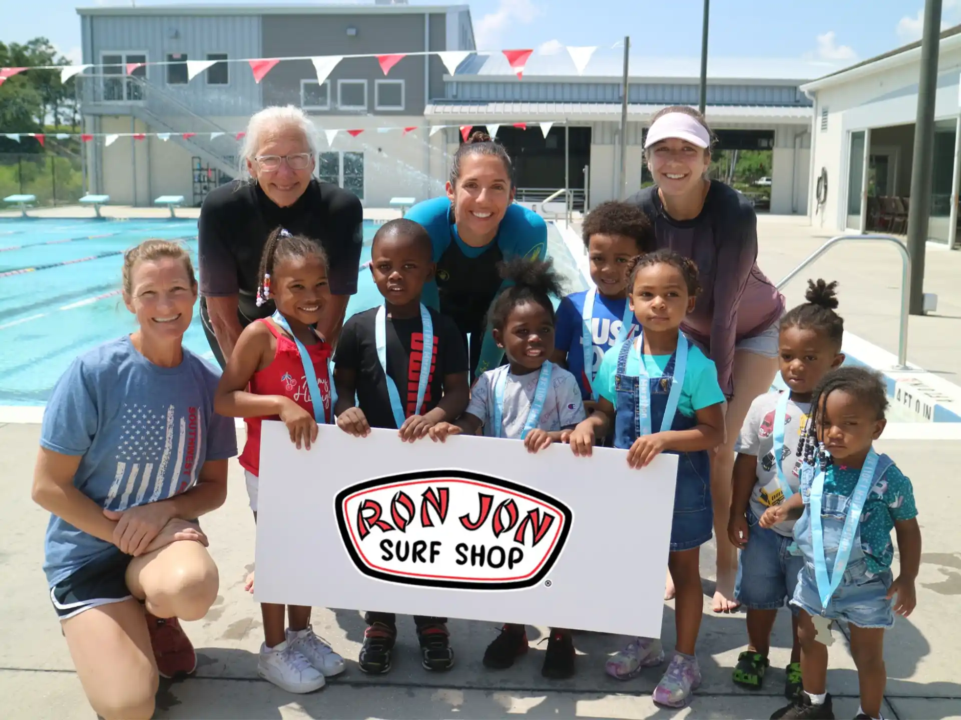 a group of people posing for a photo with a sign