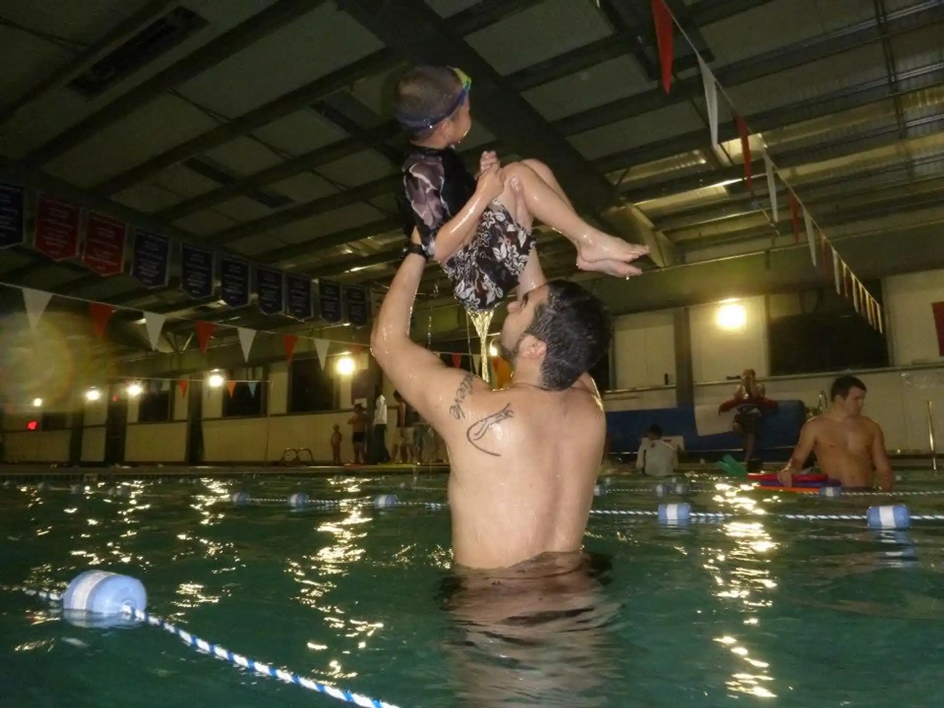 a man holding a woman in a pool