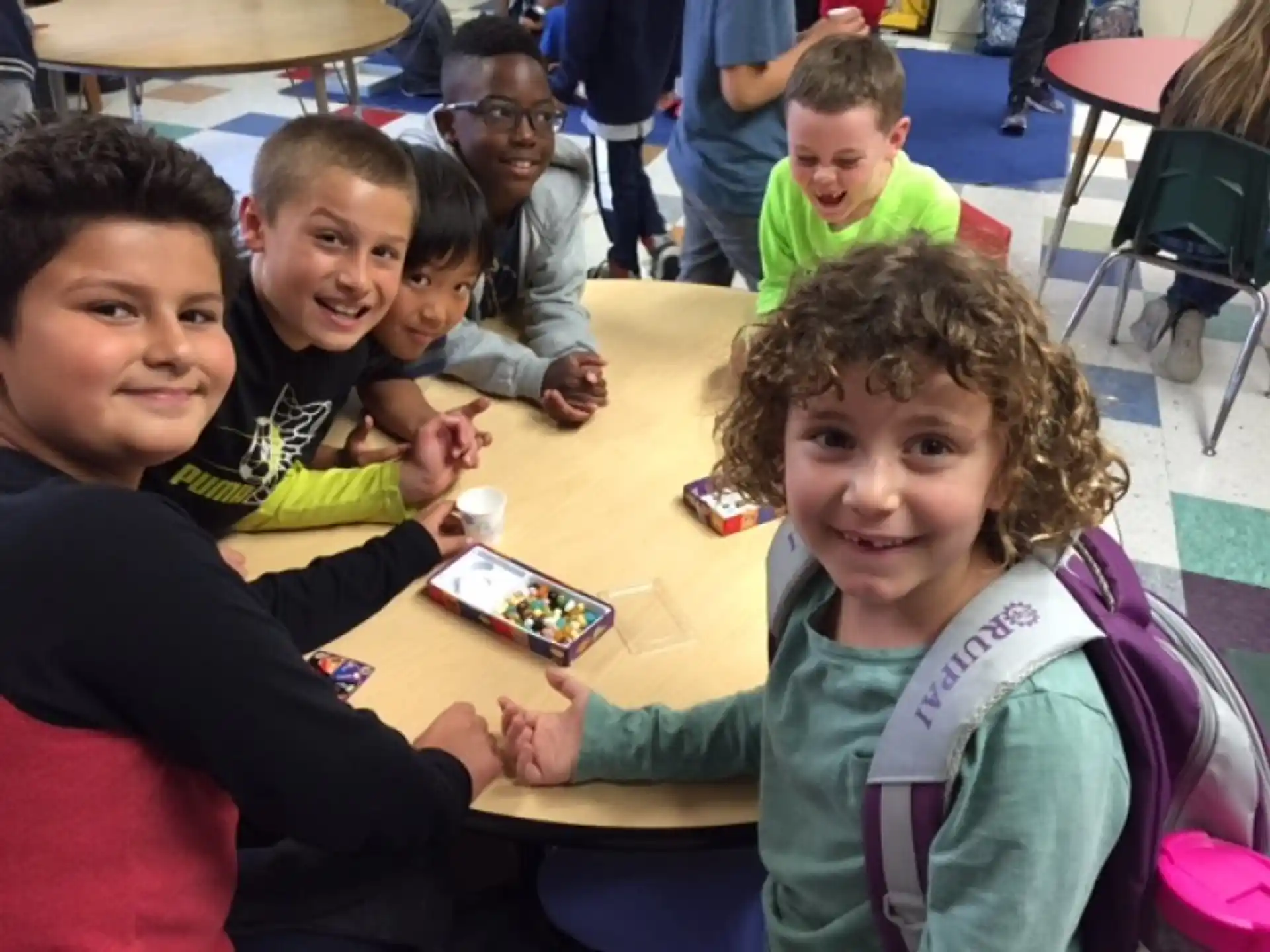 a group of children sitting at a table playing a board game