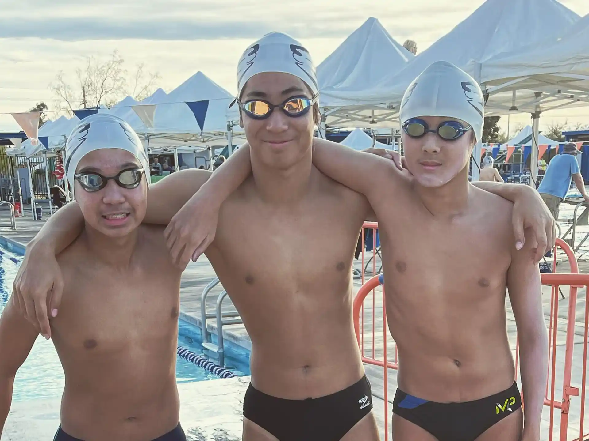 a group of men wearing swimsuits and standing in a pool