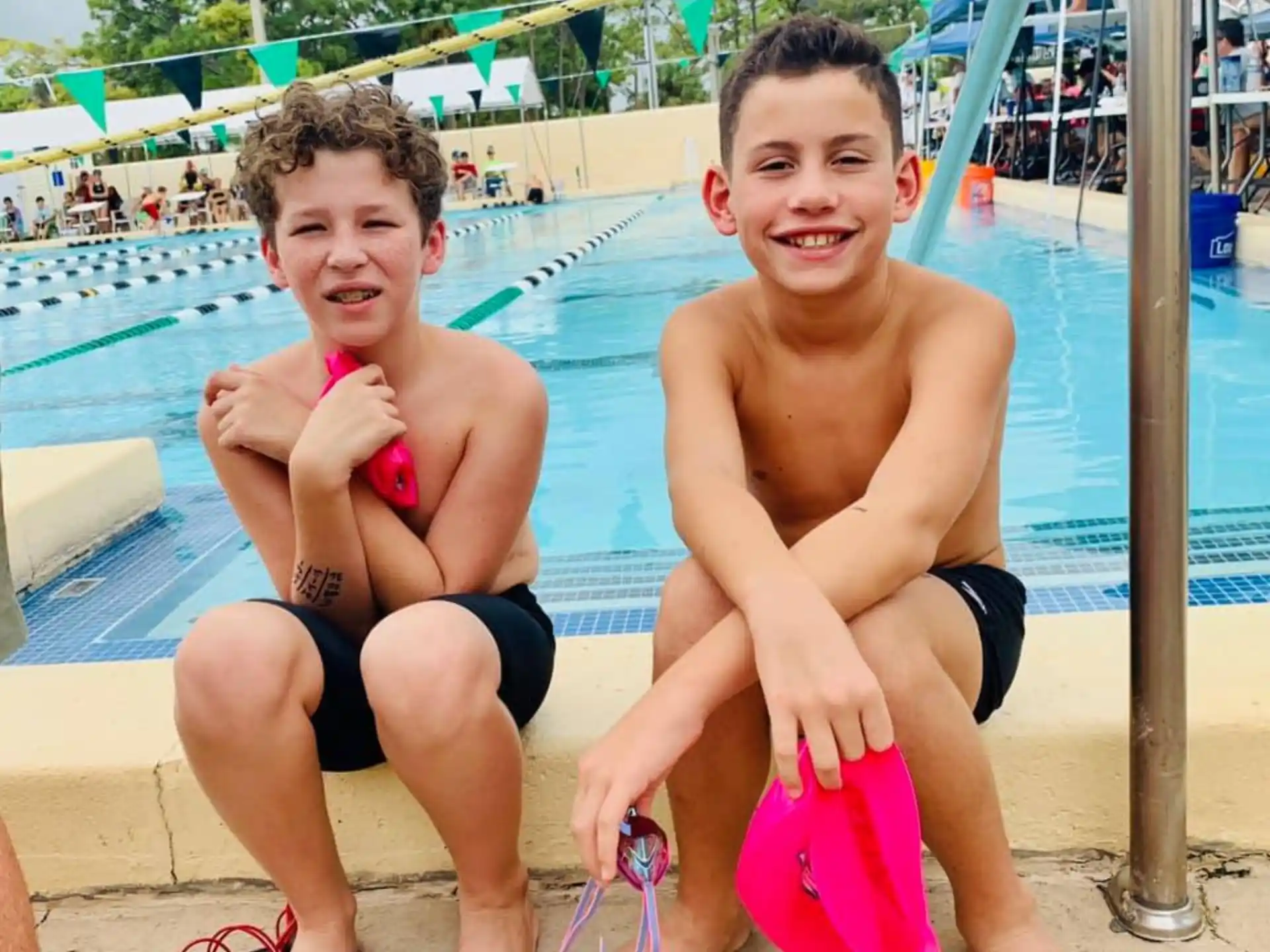 two boys sitting on a pool