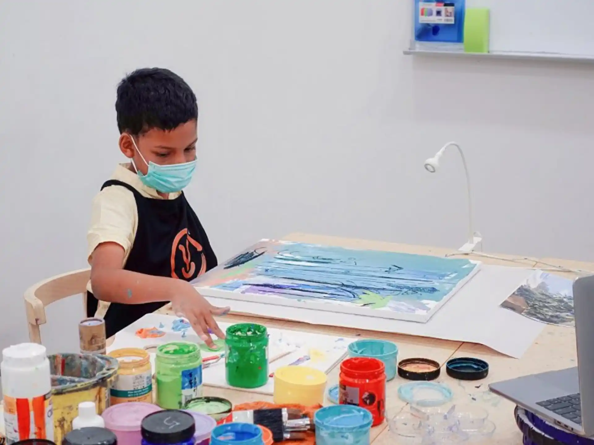 a boy wearing a mask and a mask looking at a book