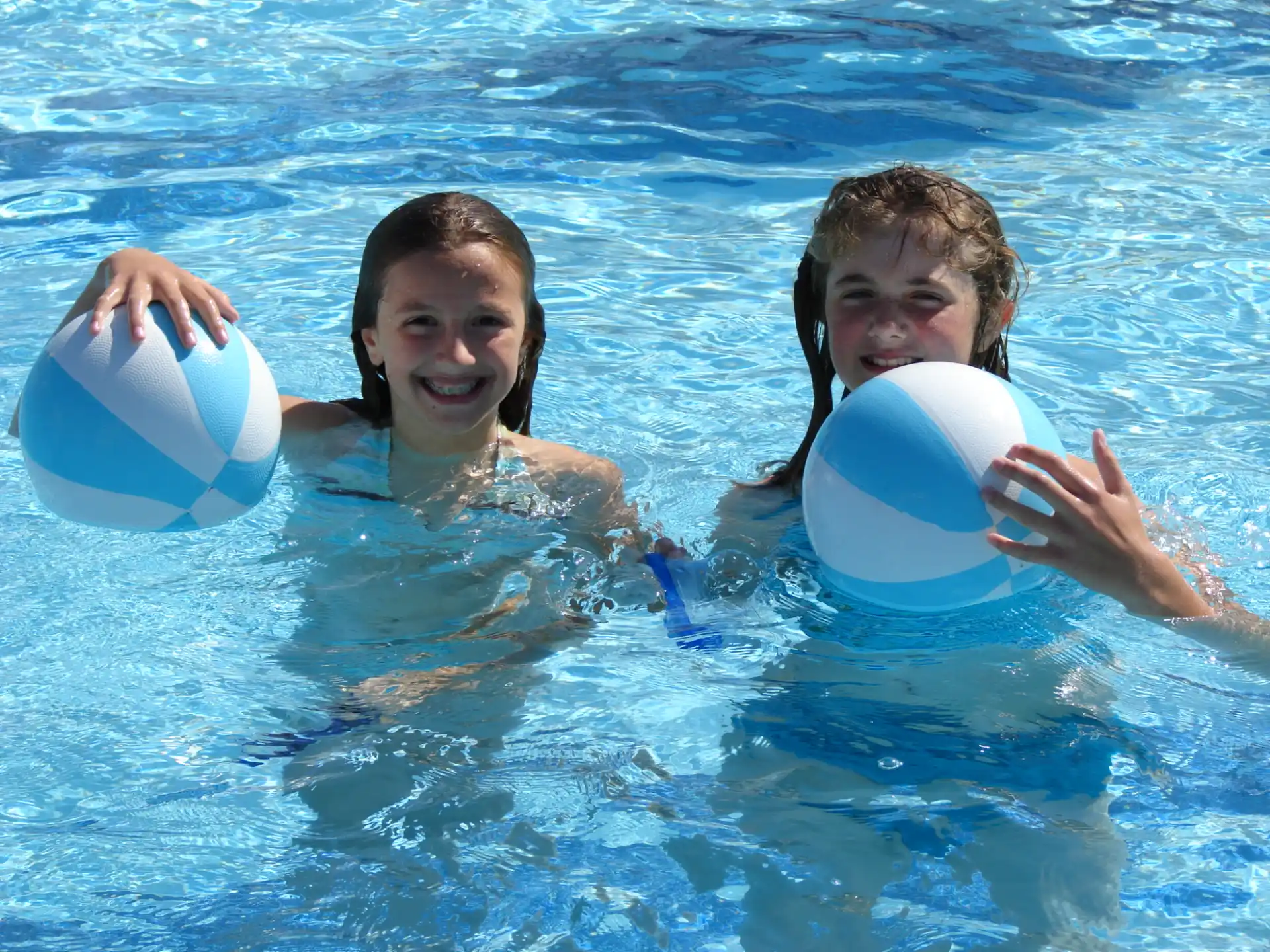 a couple of kids playing in the water with a frisbee