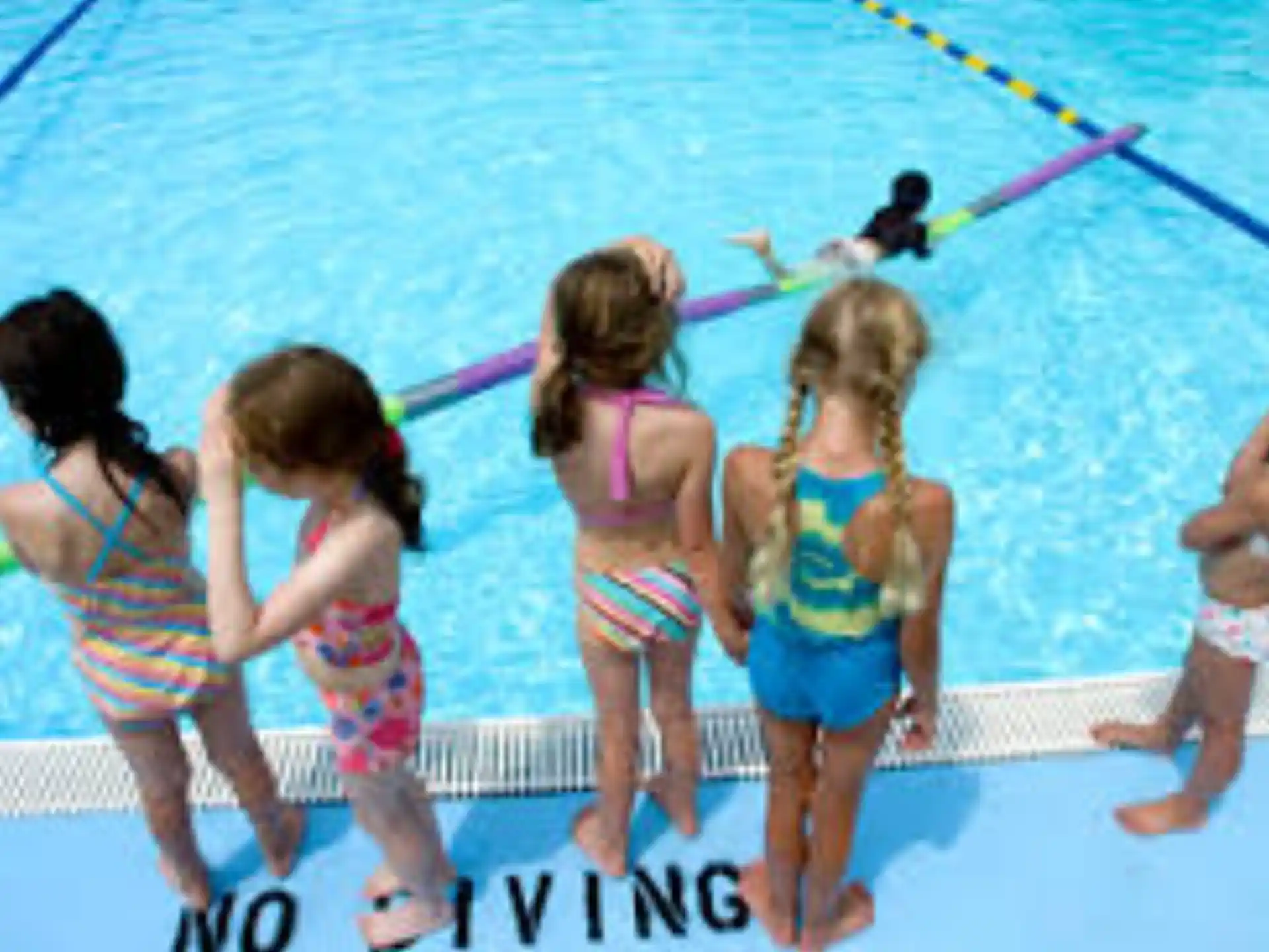 a group of girls in swimsuits on a pool