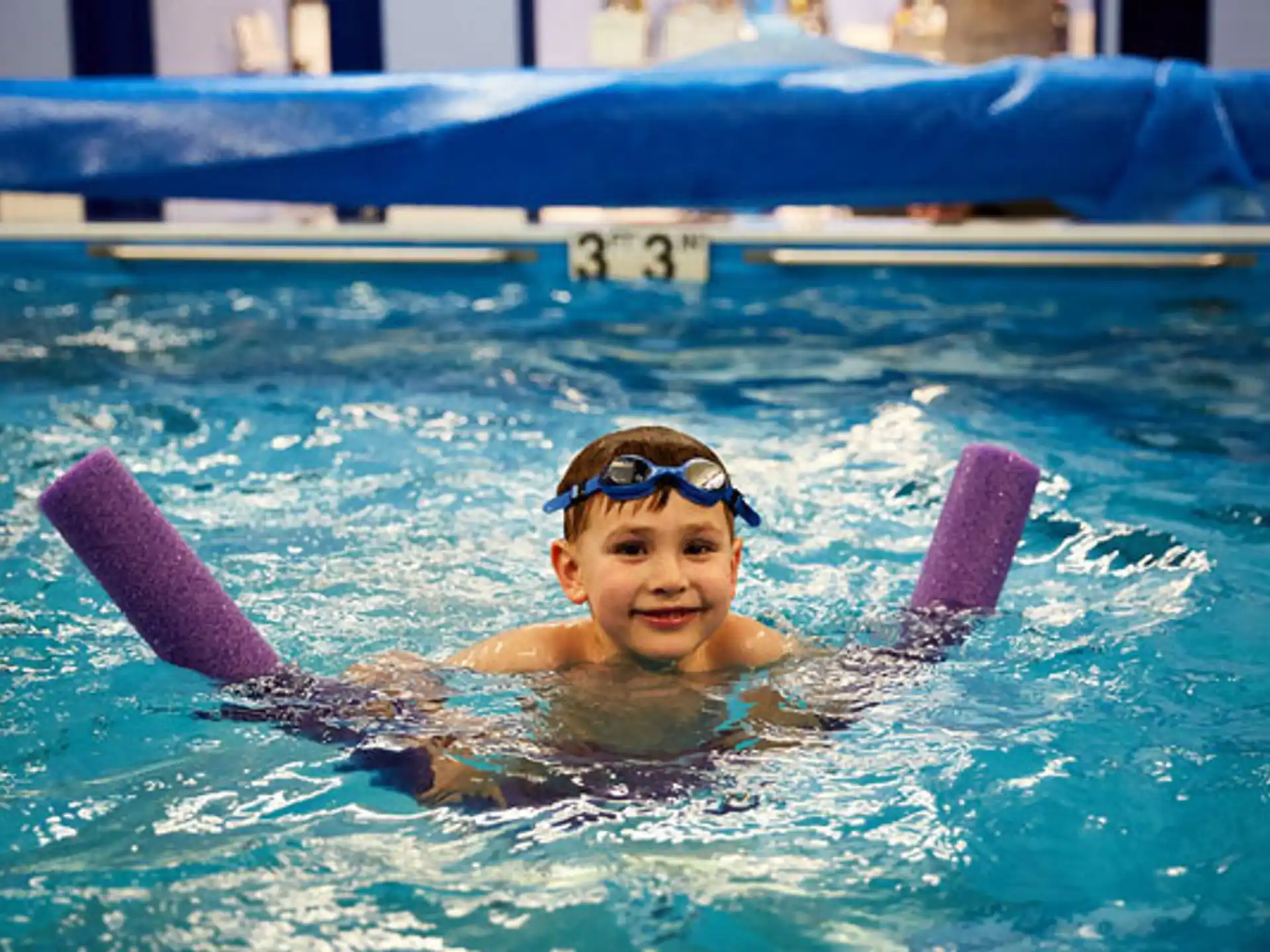 a boy in a pool with a dolphin