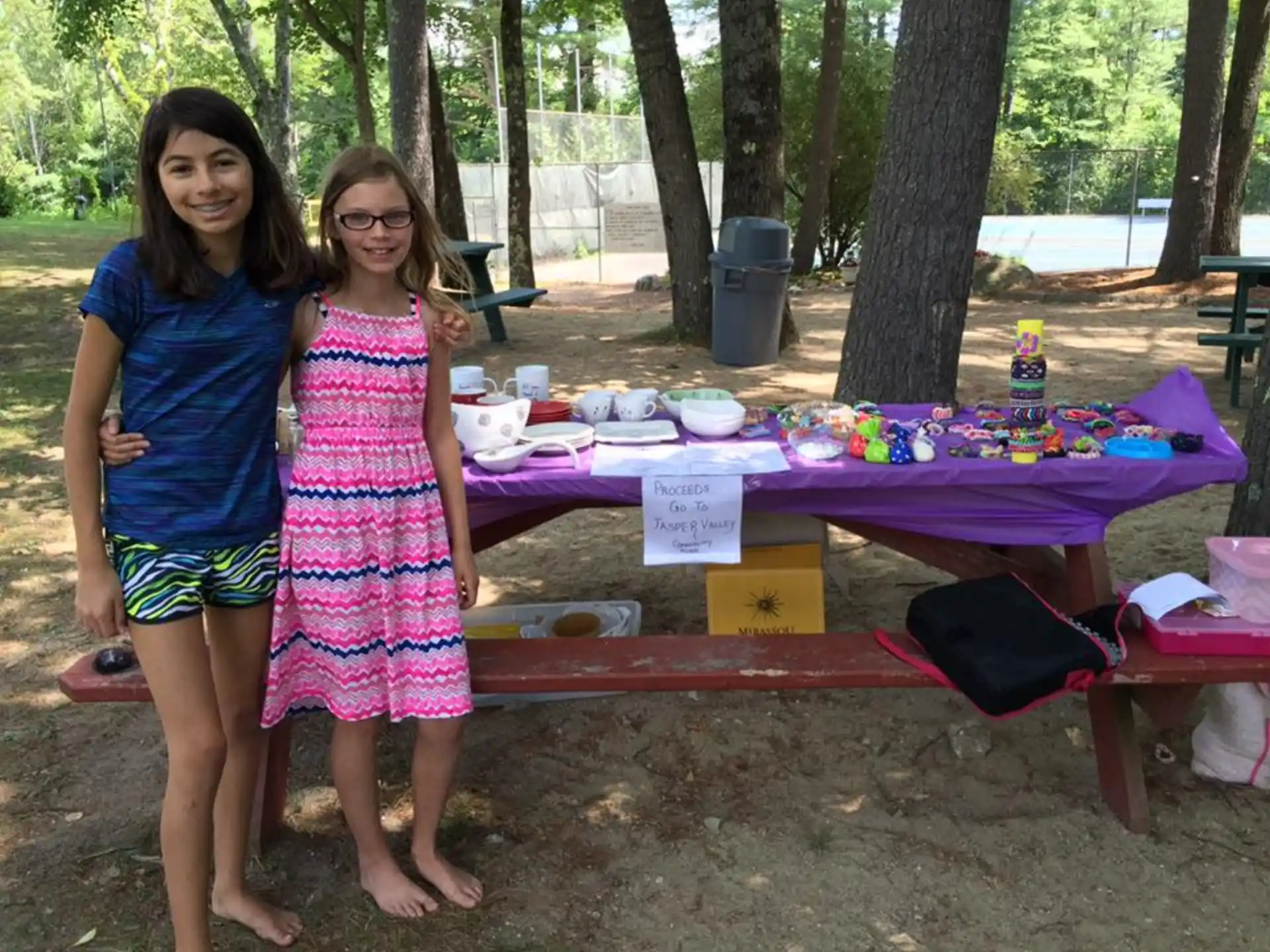 a group of women standing next to a table with food and drinks