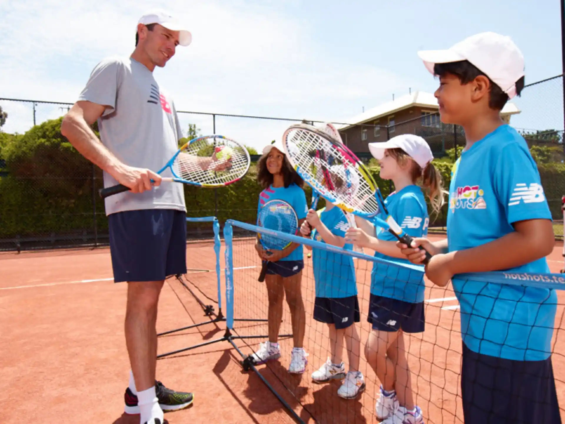 a group of kids playing tennis