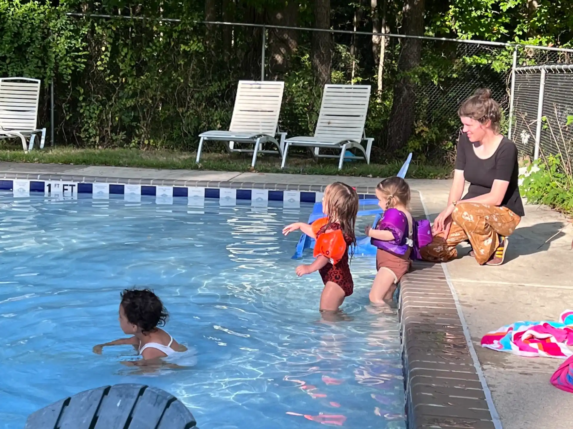 a person and two children in a swimming pool