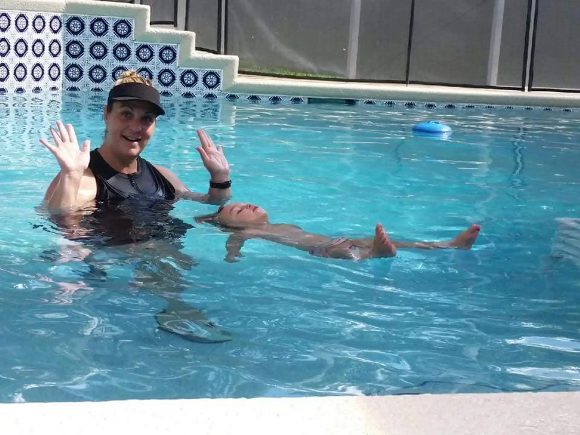 a person in a pool with the hands up