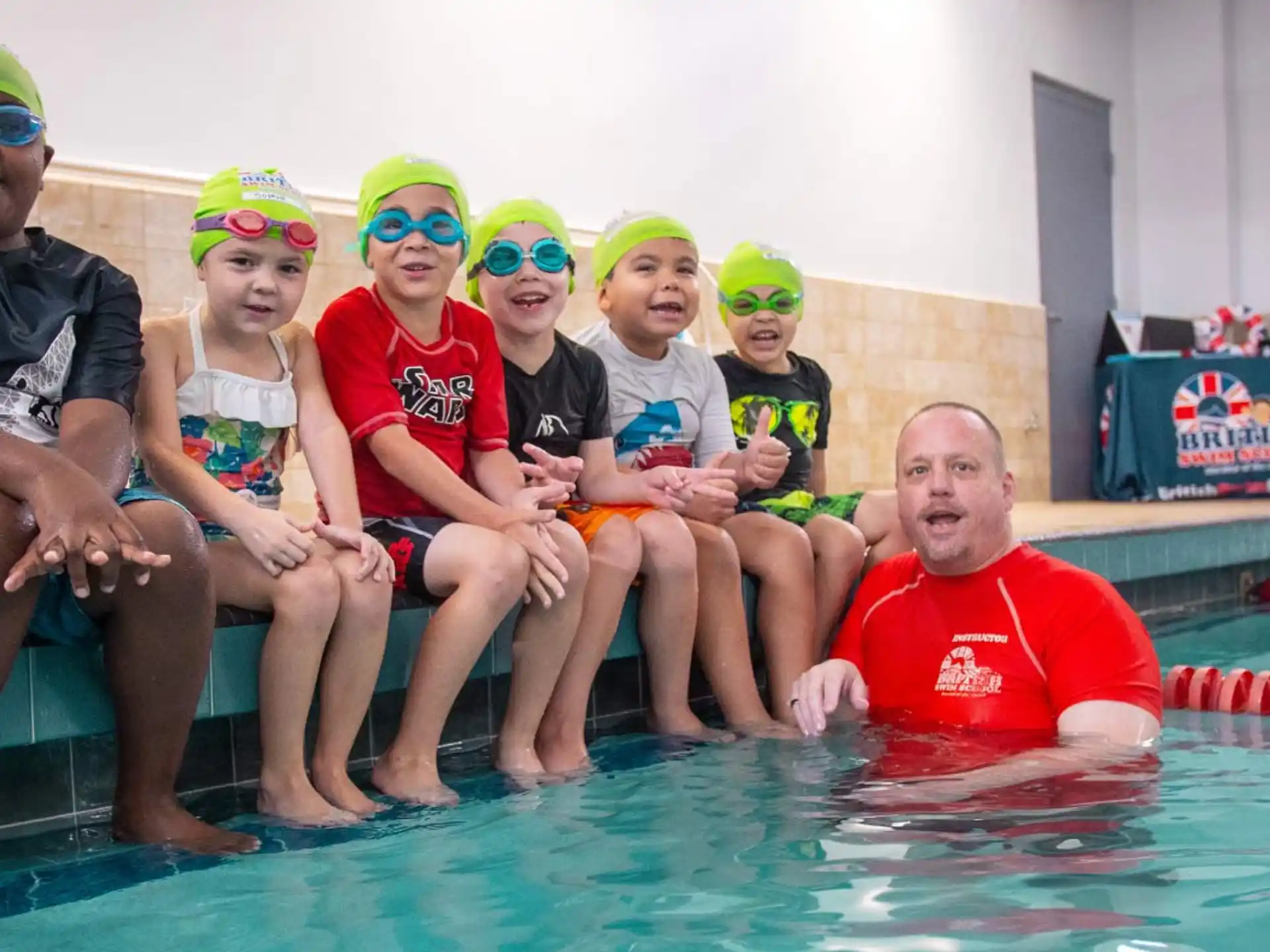 a group of people sitting in a pool wearing goggles