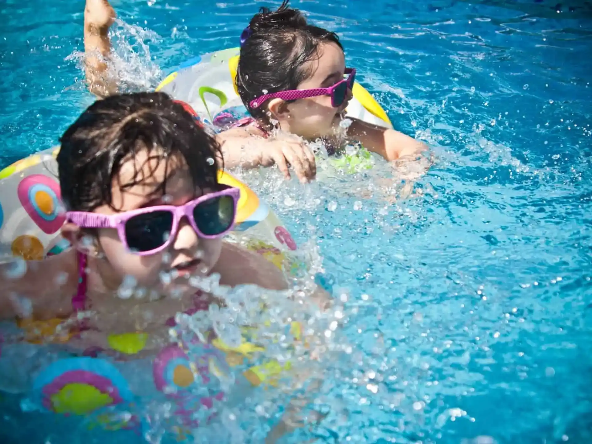a couple of people swimming in a pool
