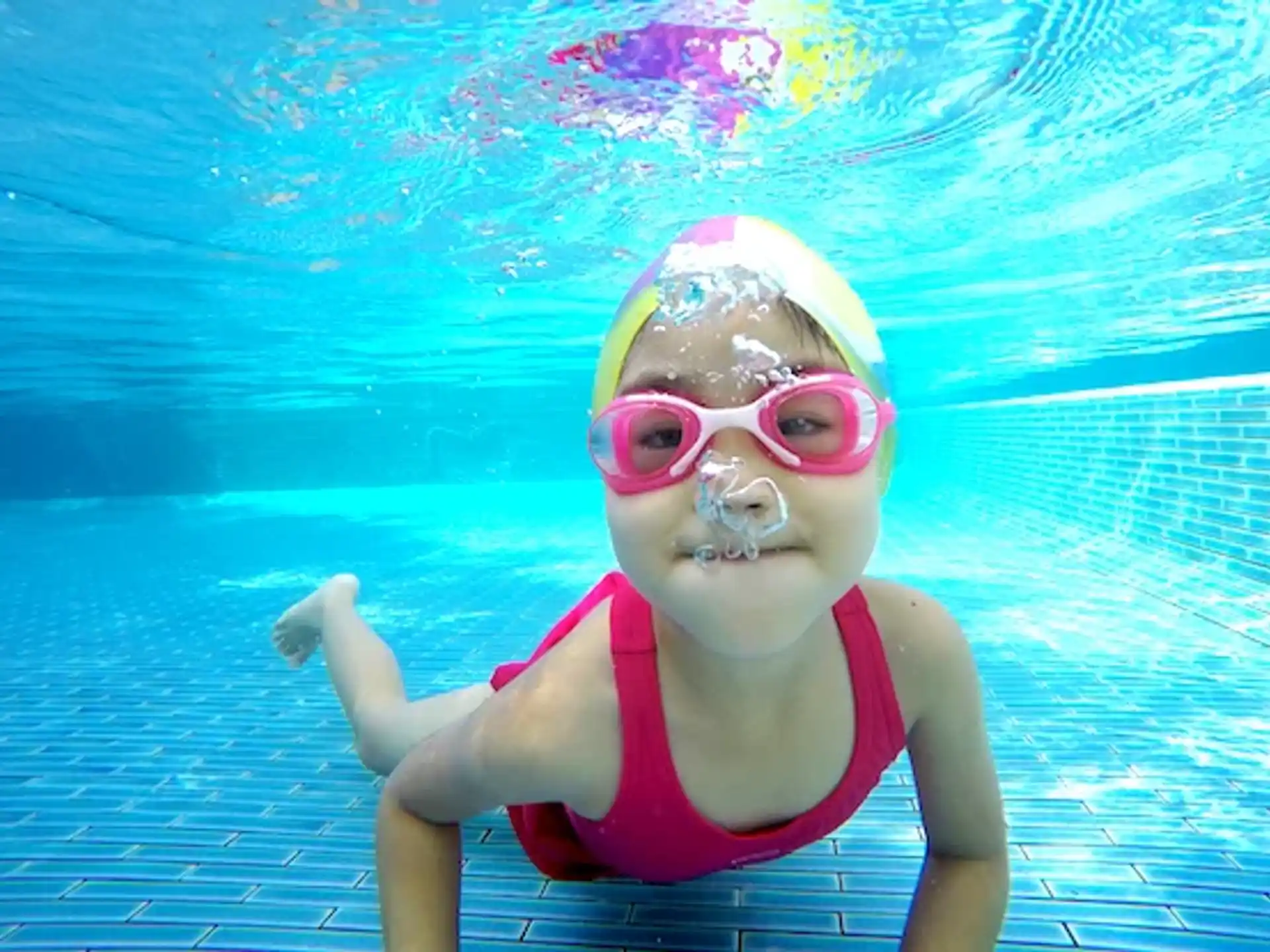 a girl wearing goggles and swimming