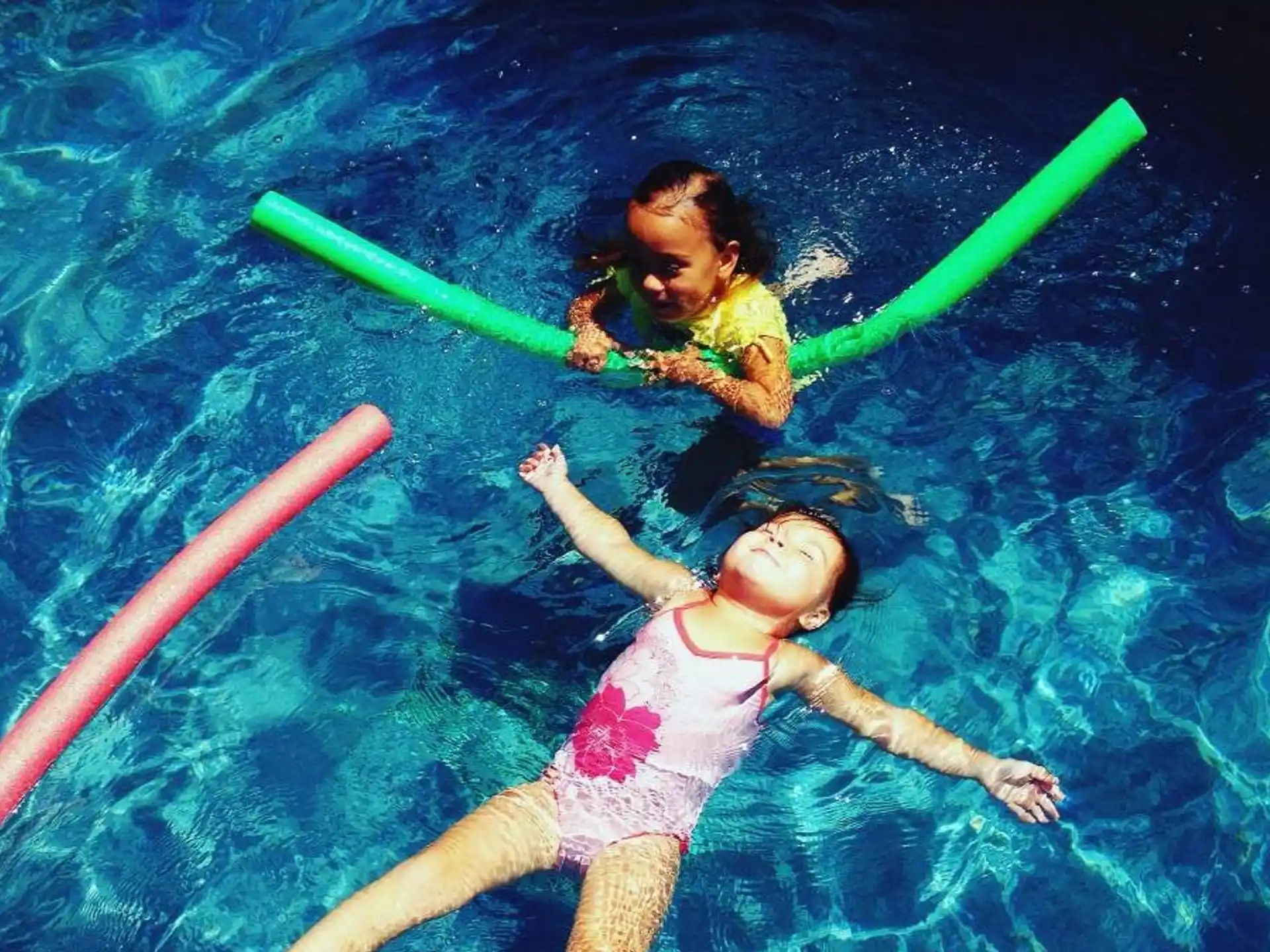 a couple of kids in a pool