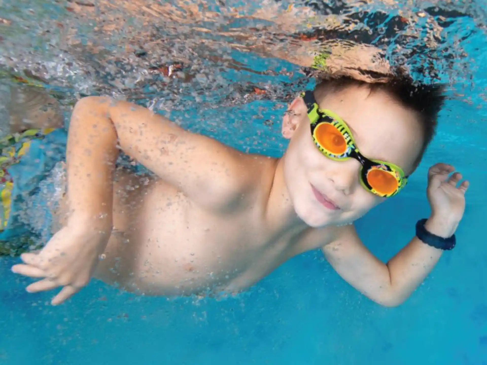 a person wearing goggles and swimming in a pool