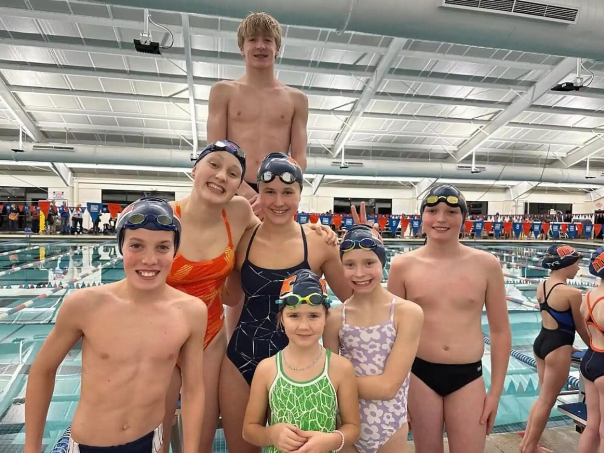 a group of people posing for a photo in a swimming pool