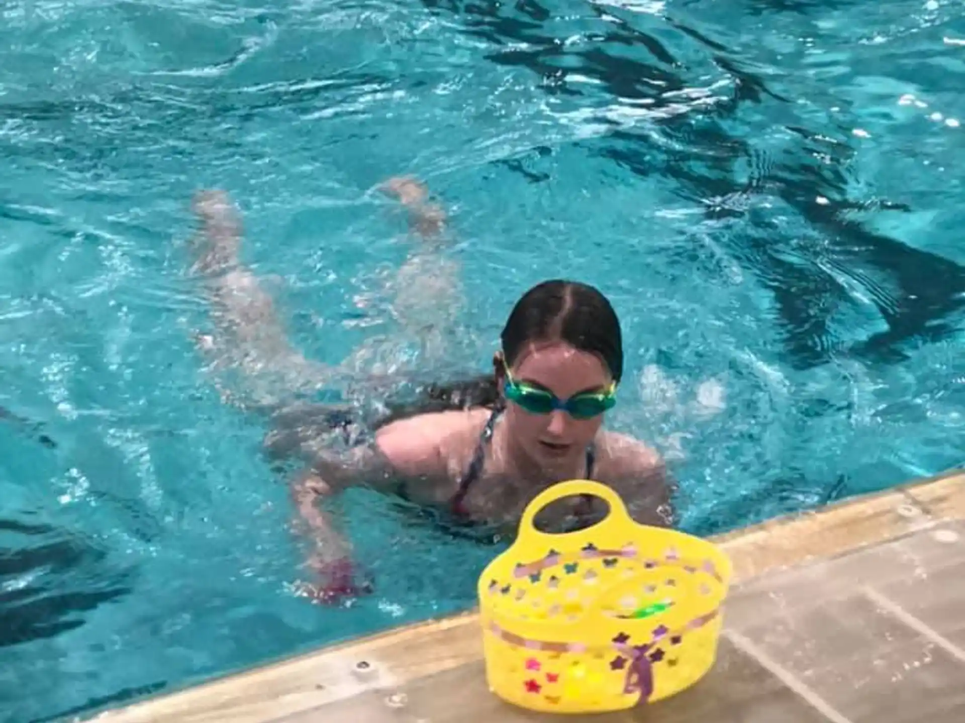 a person in a pool with a yellow floaty