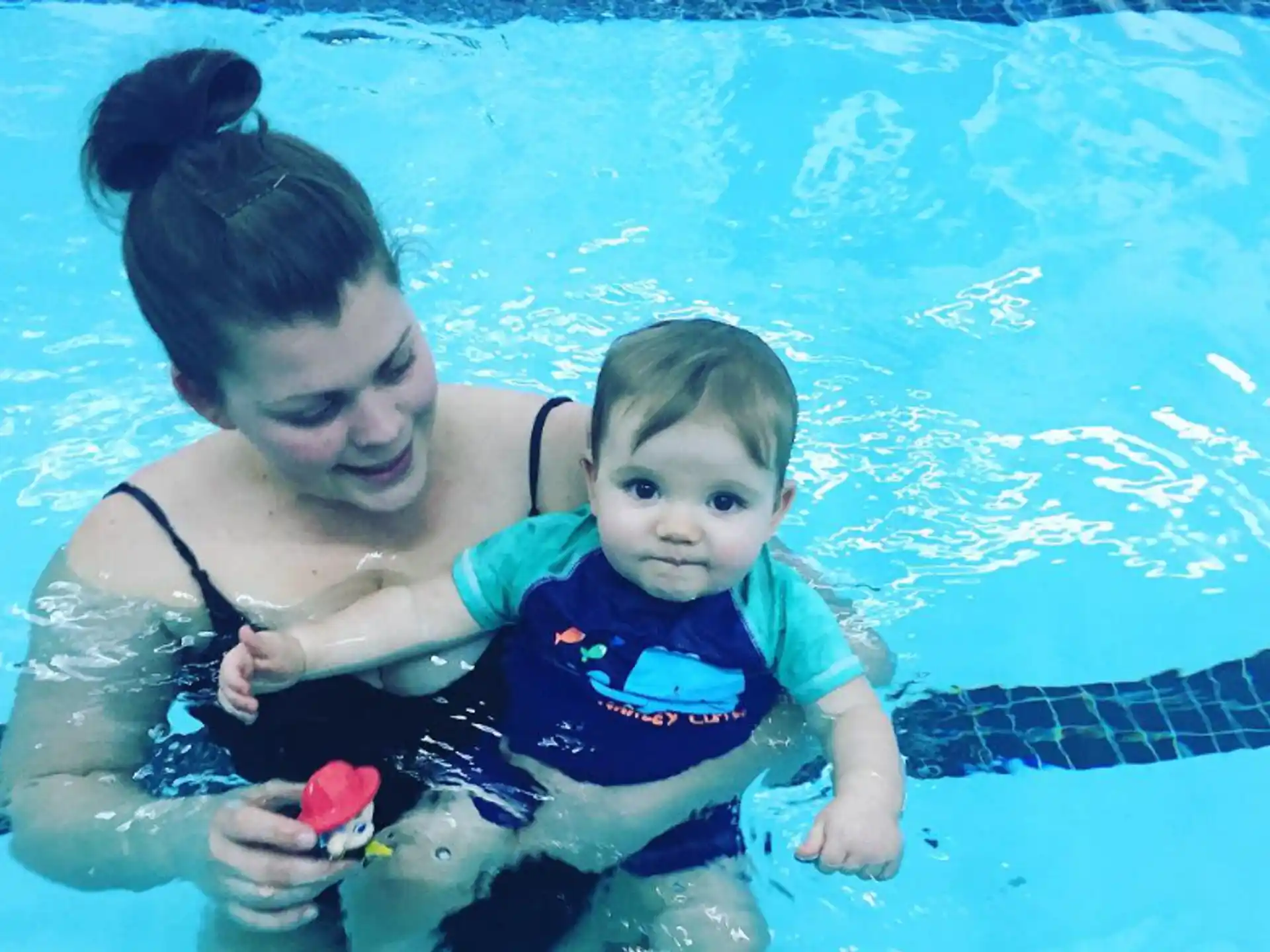 a person and a baby in a pool