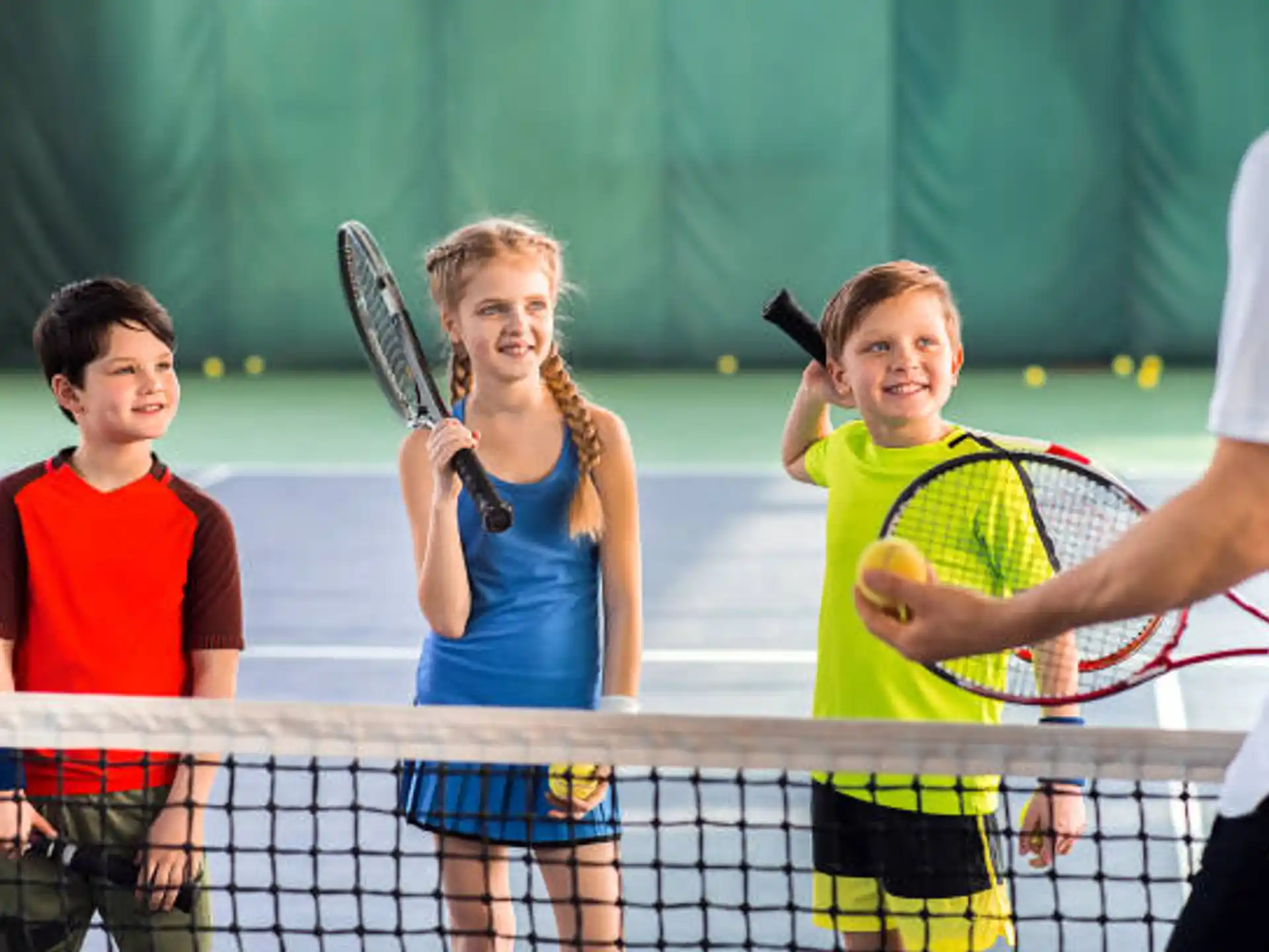 a group of kids playing tennis