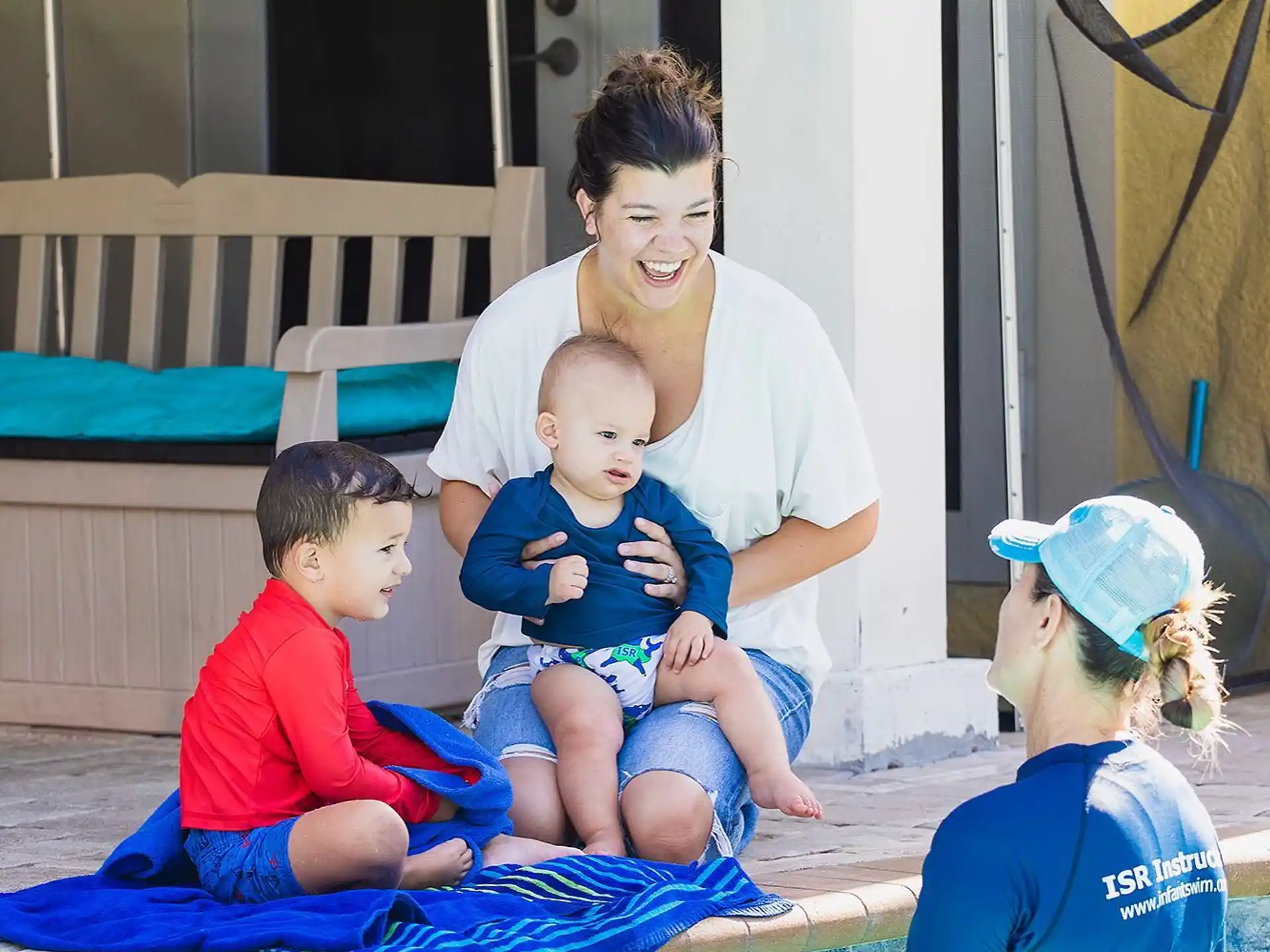 a person and two children sitting on a mat in a play area