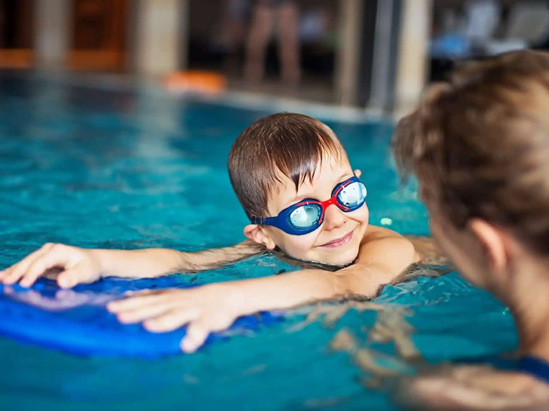 a boy wearing goggles in a pool