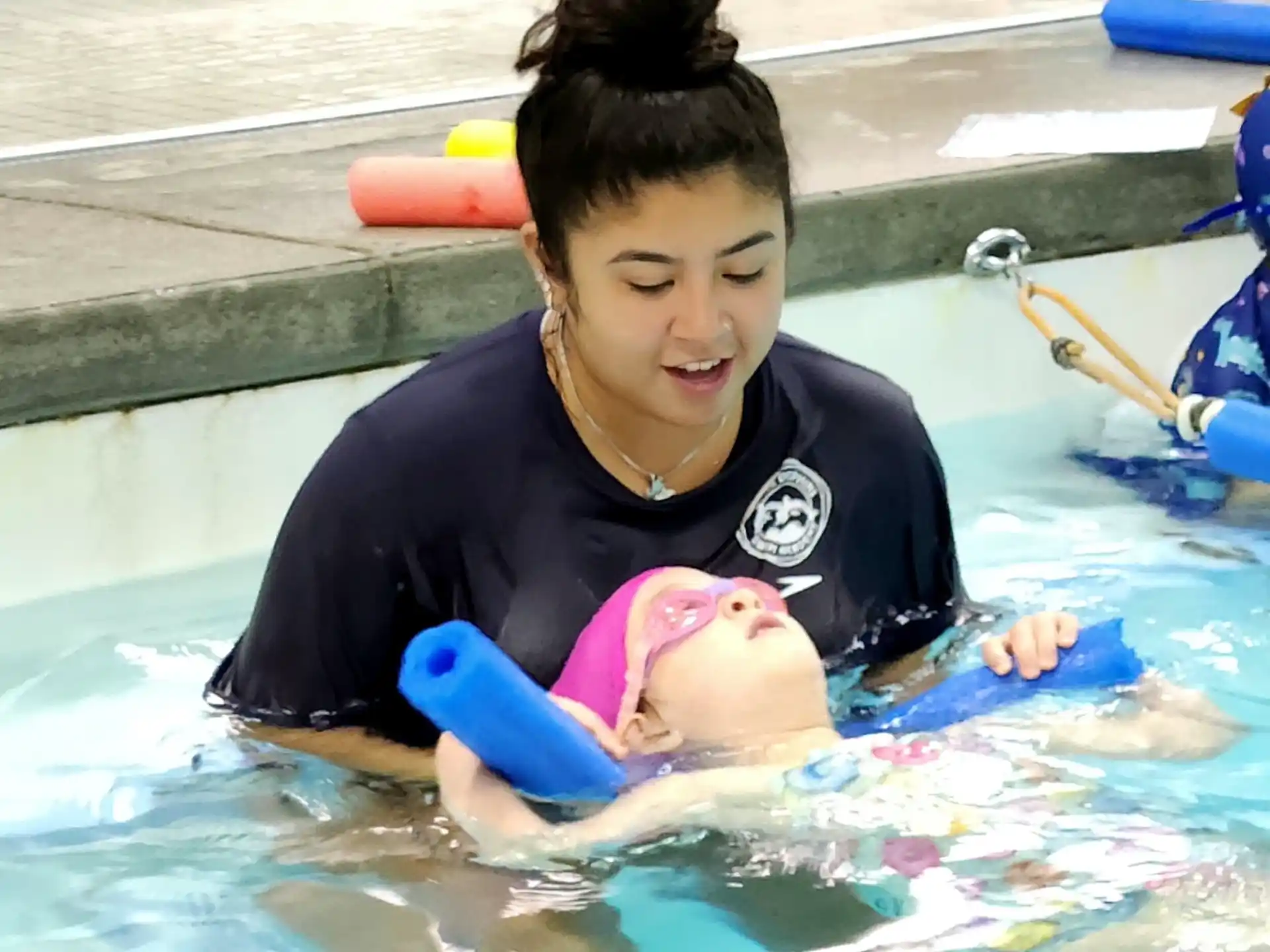 a person in a pool with a baby in a pool