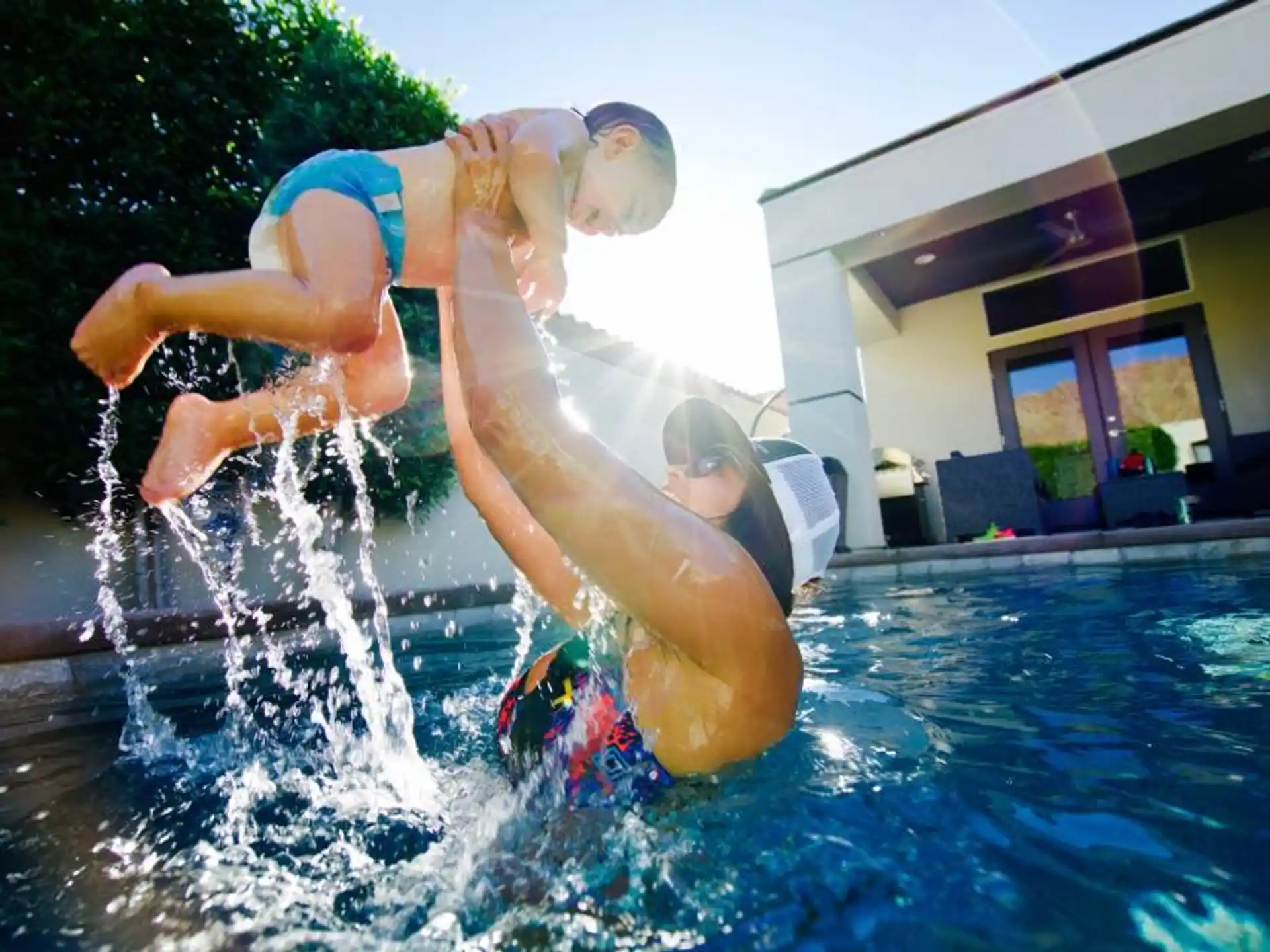 a man and a woman jumping into a pool