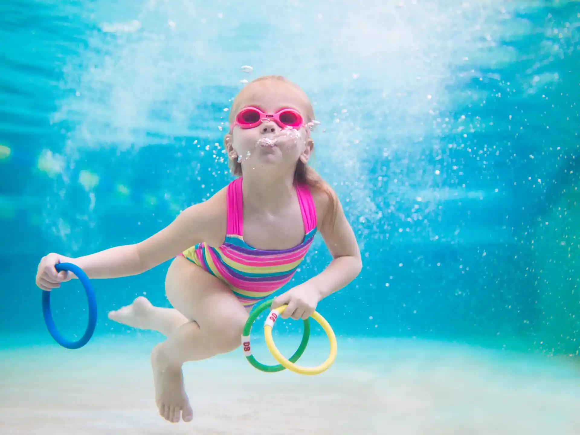 a girl in a swimsuit playing with a frisbee