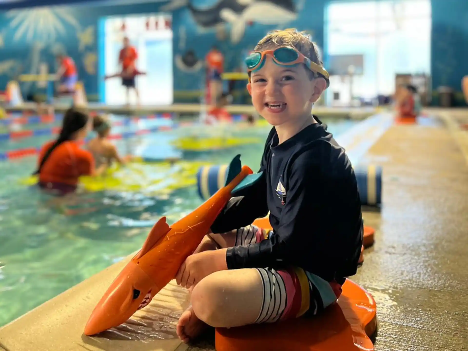 a boy in a pool holding a toy gun