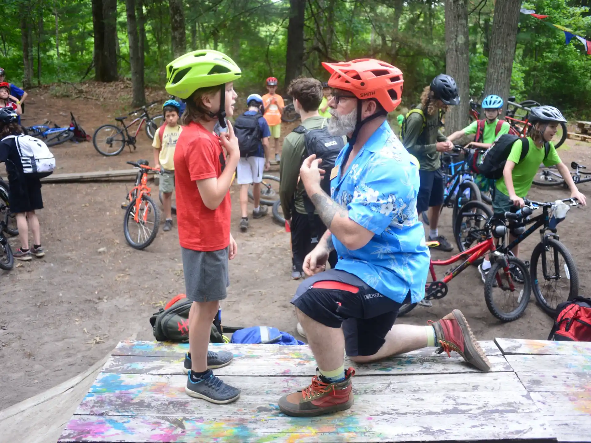 a group of people with helmets and bikes in a park