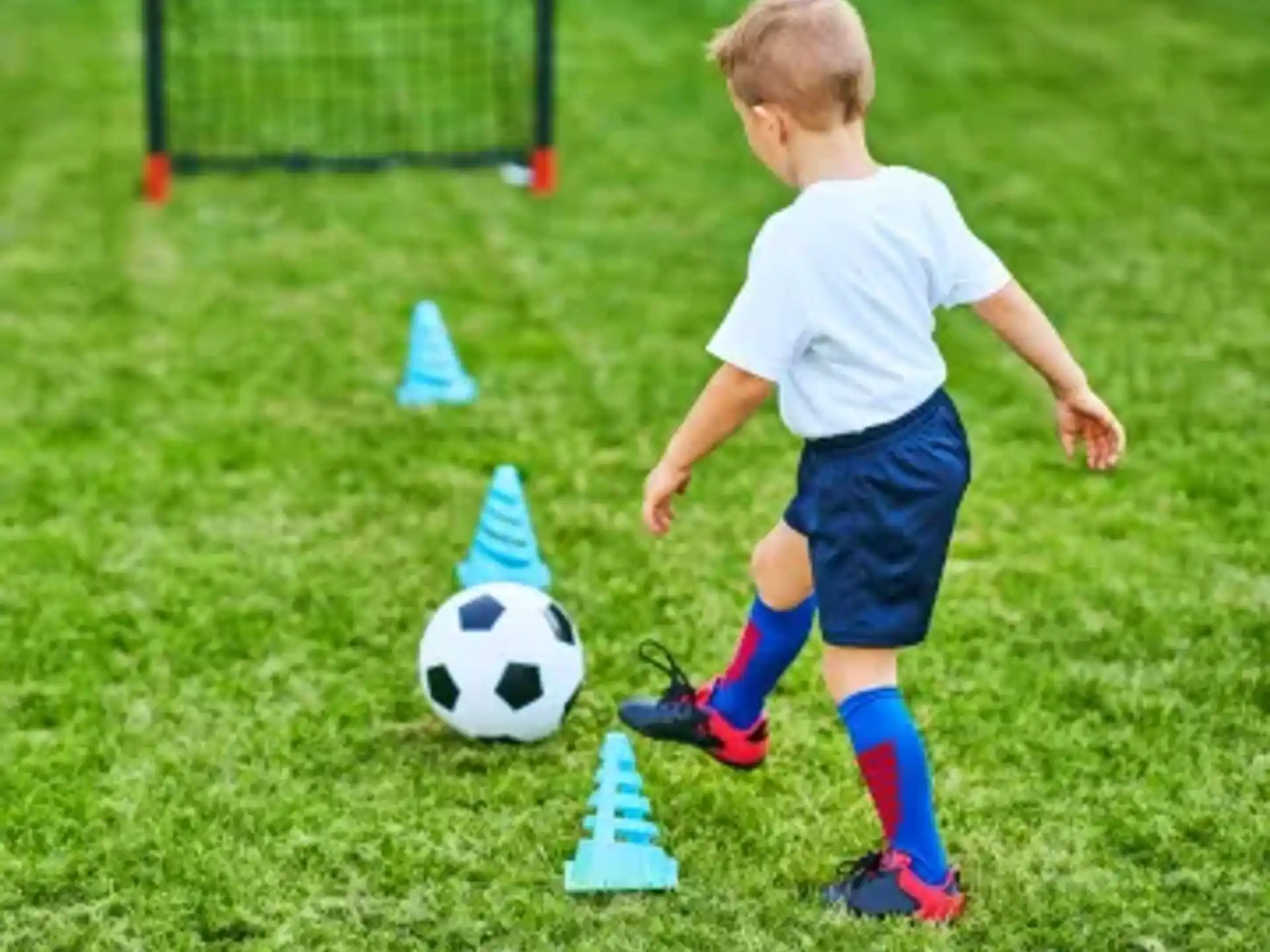 a boy playing with a football ball