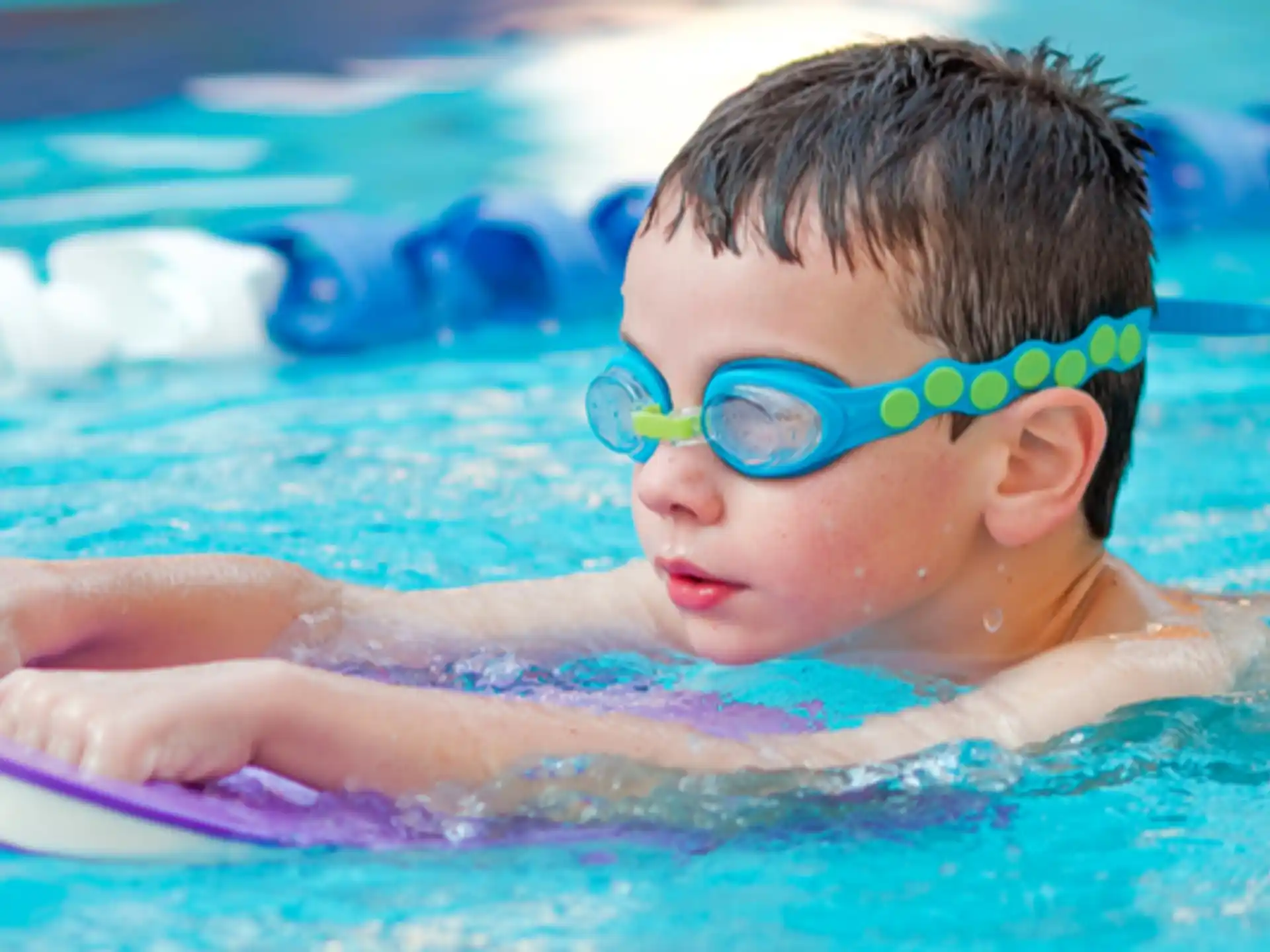a baby wearing goggles in a pool