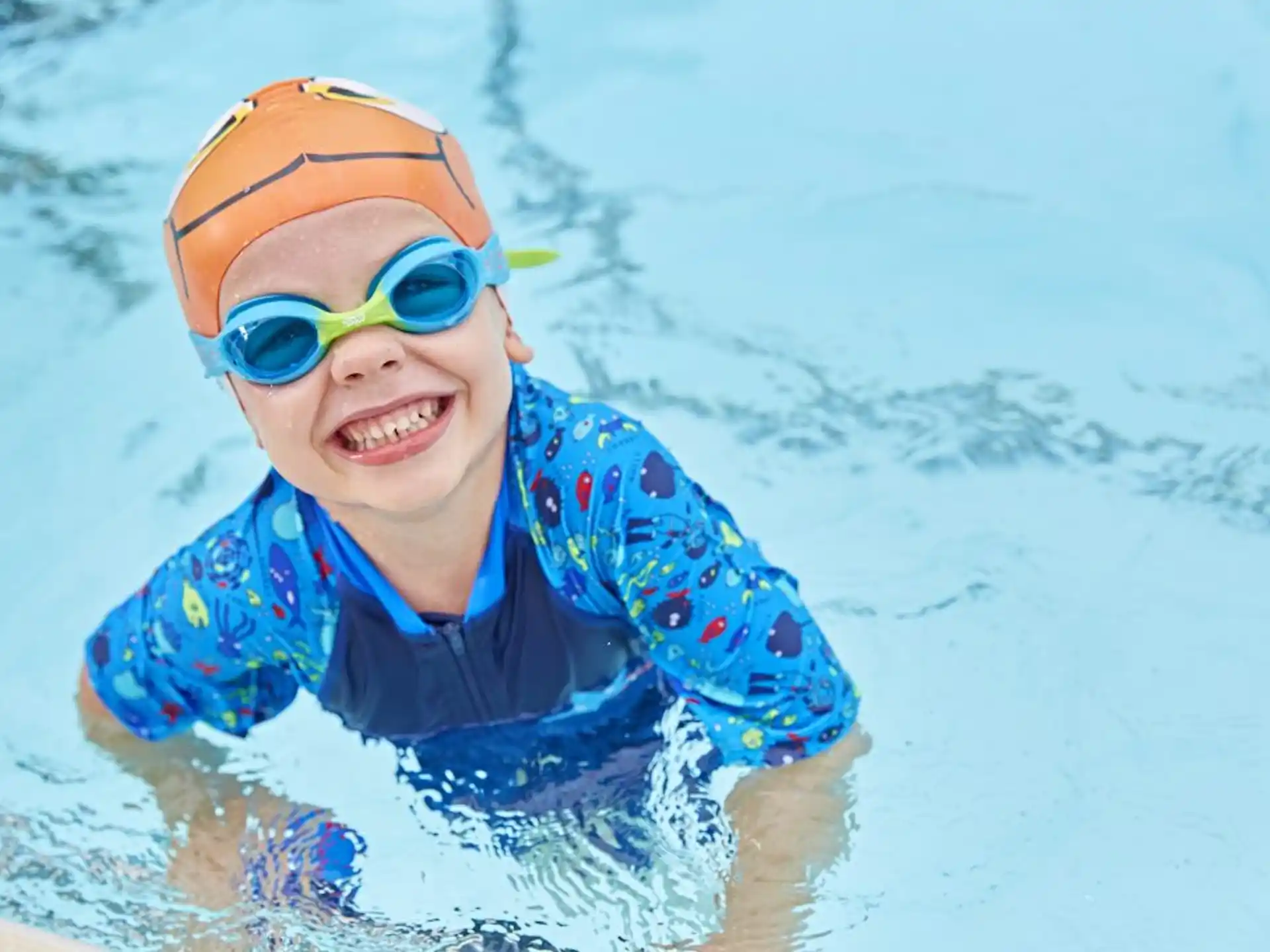 a boy wearing goggles and swimming