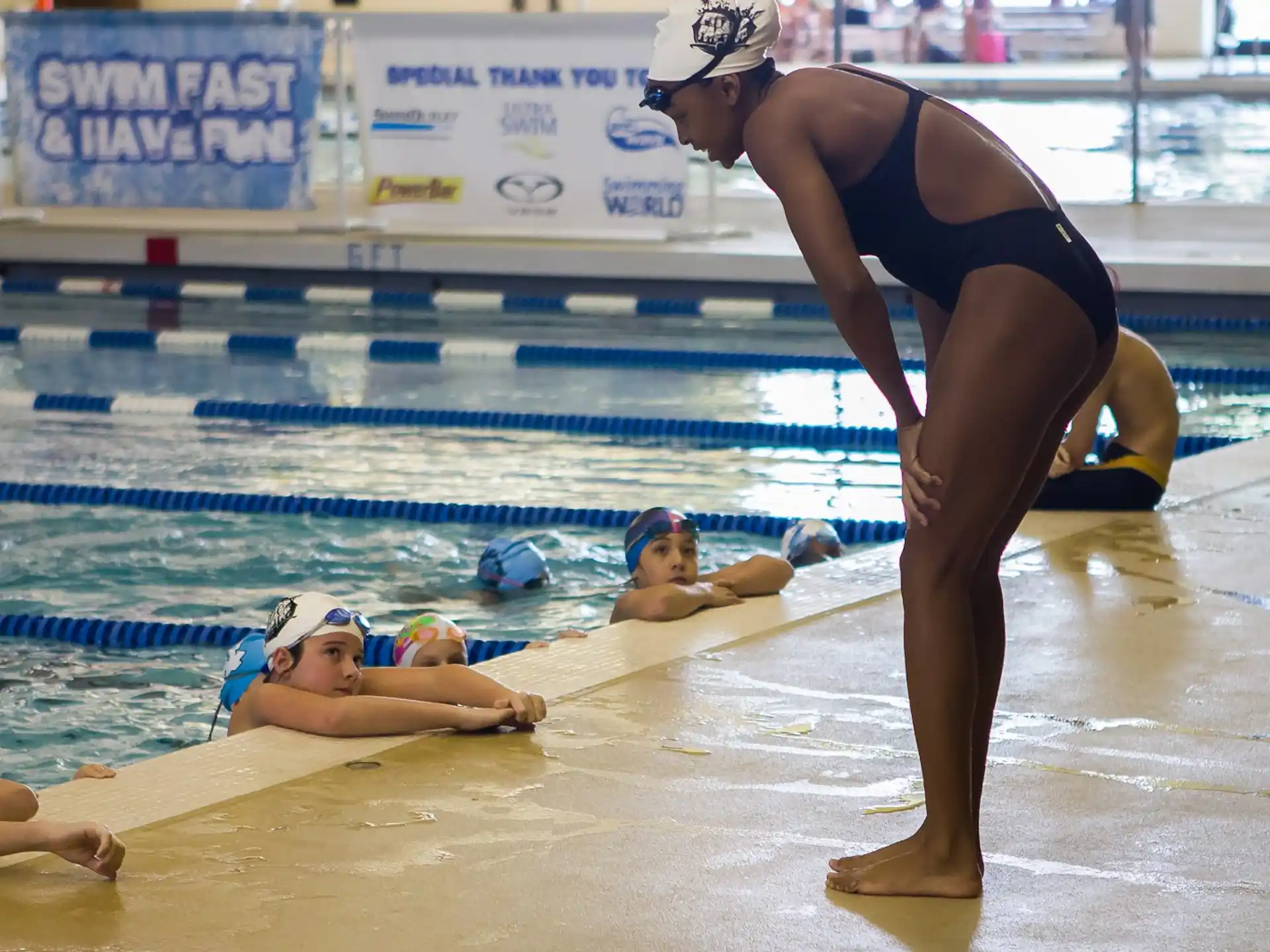a woman in a swimsuit pushing a man in a pool