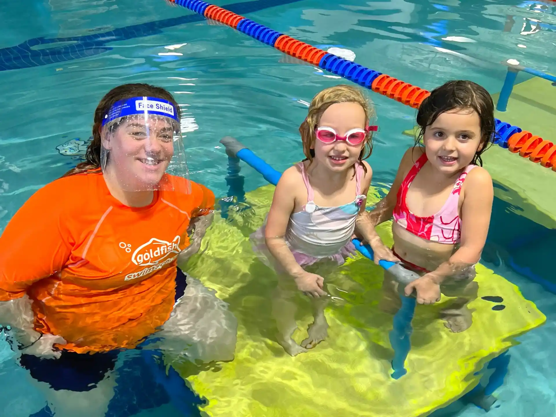a man and two children in a pool