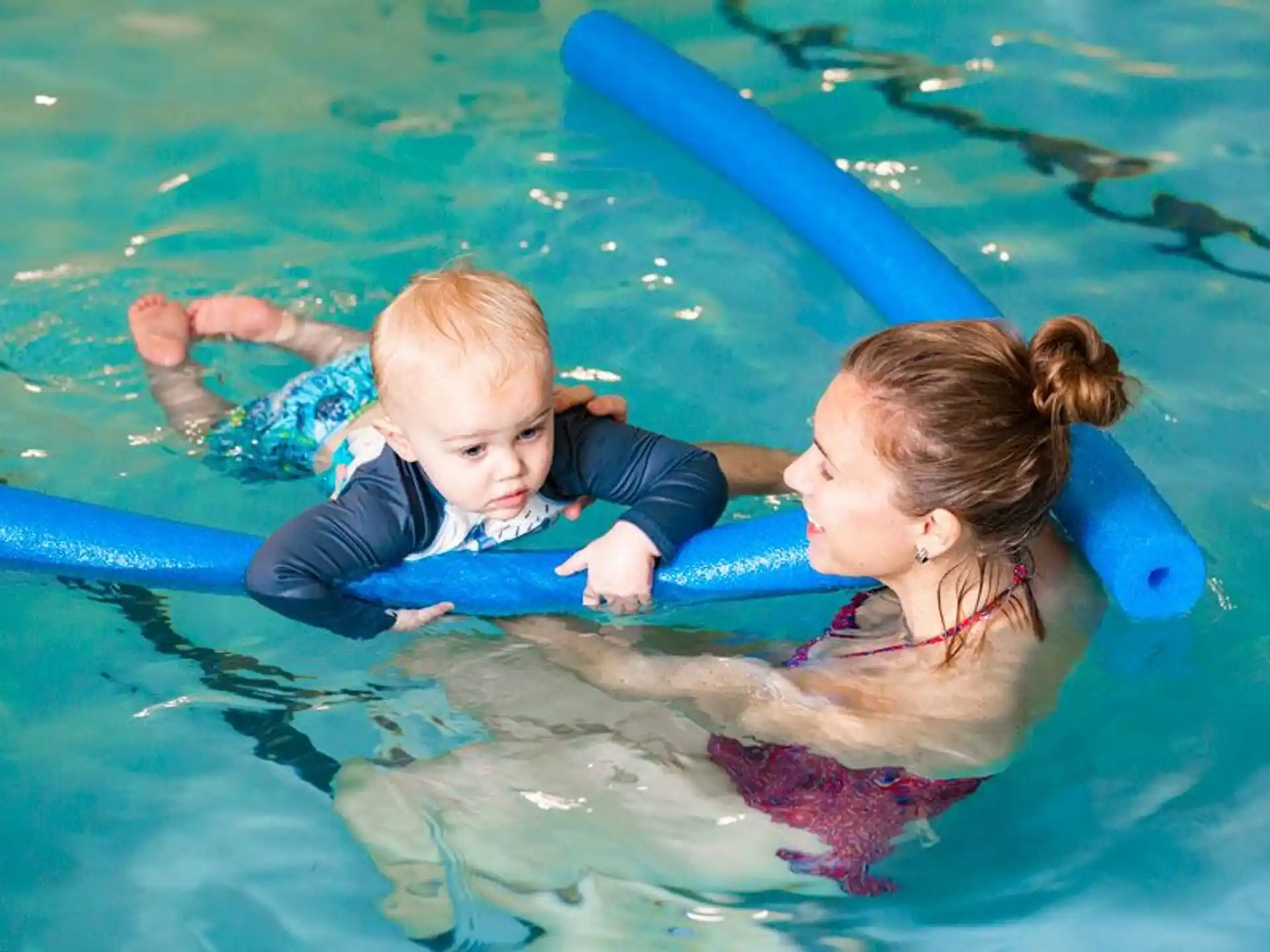 a person and a baby in a pool
