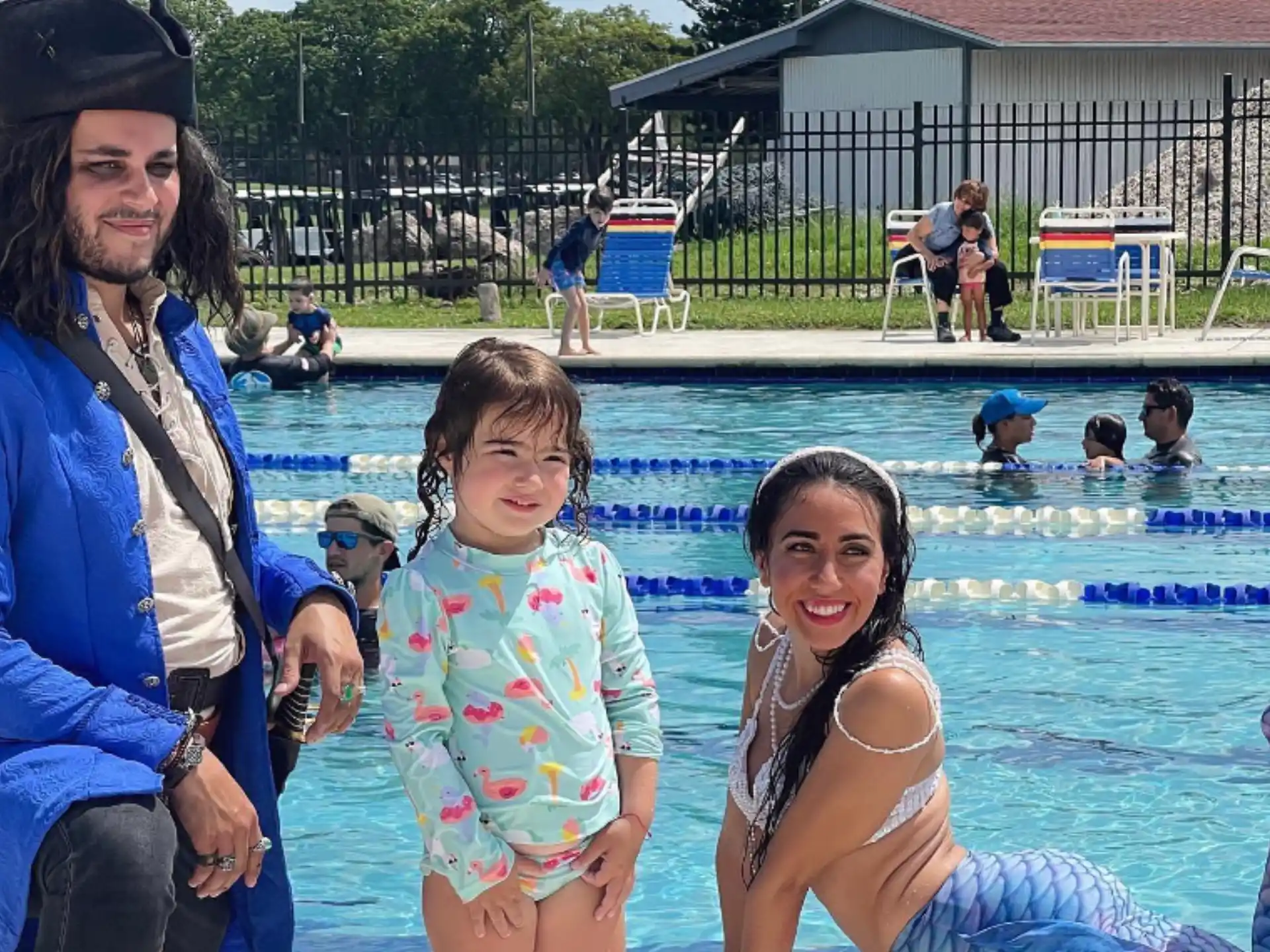 a group of people posing for a photo by a pool