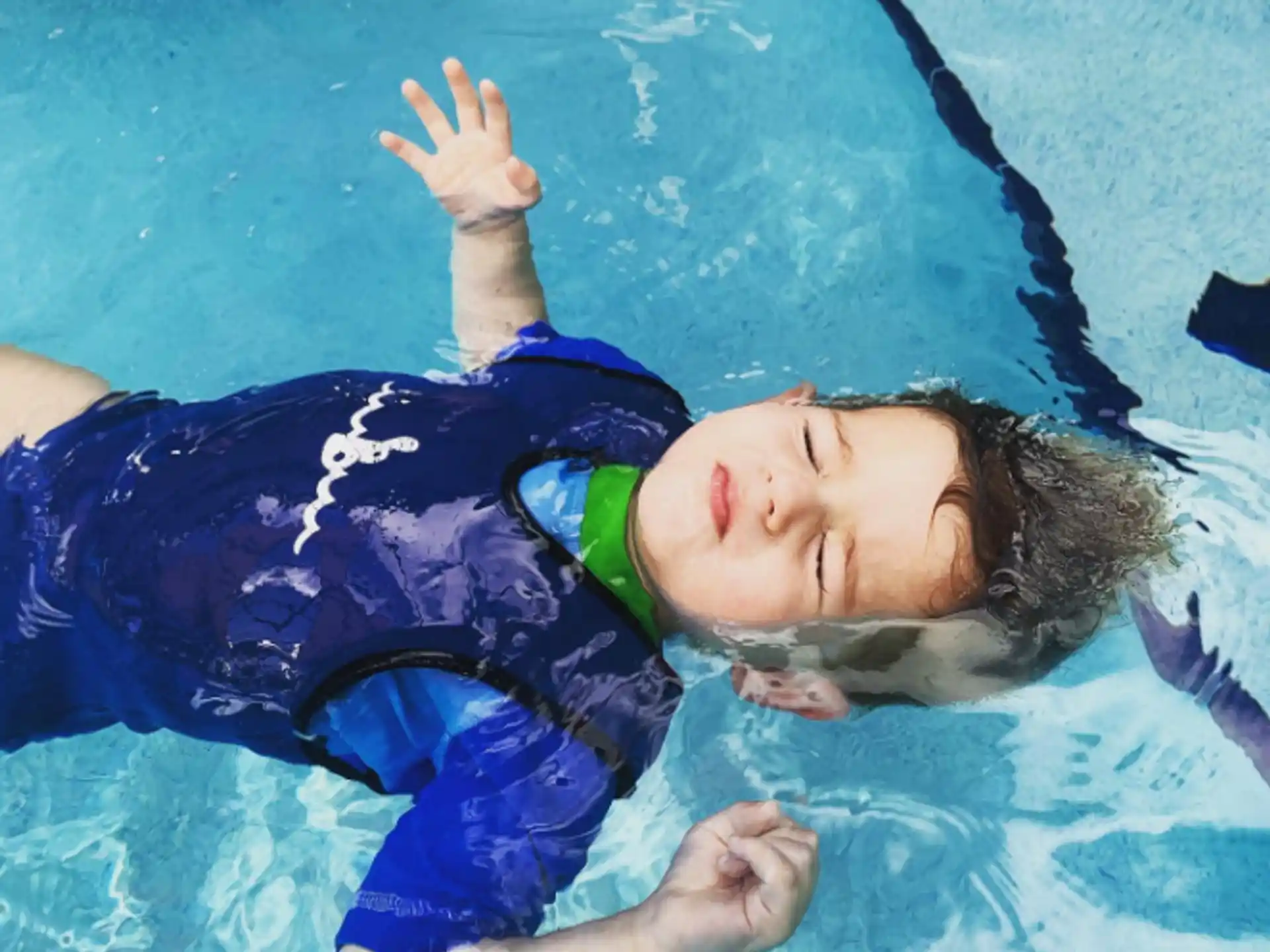 a boy lying on a blue blanket