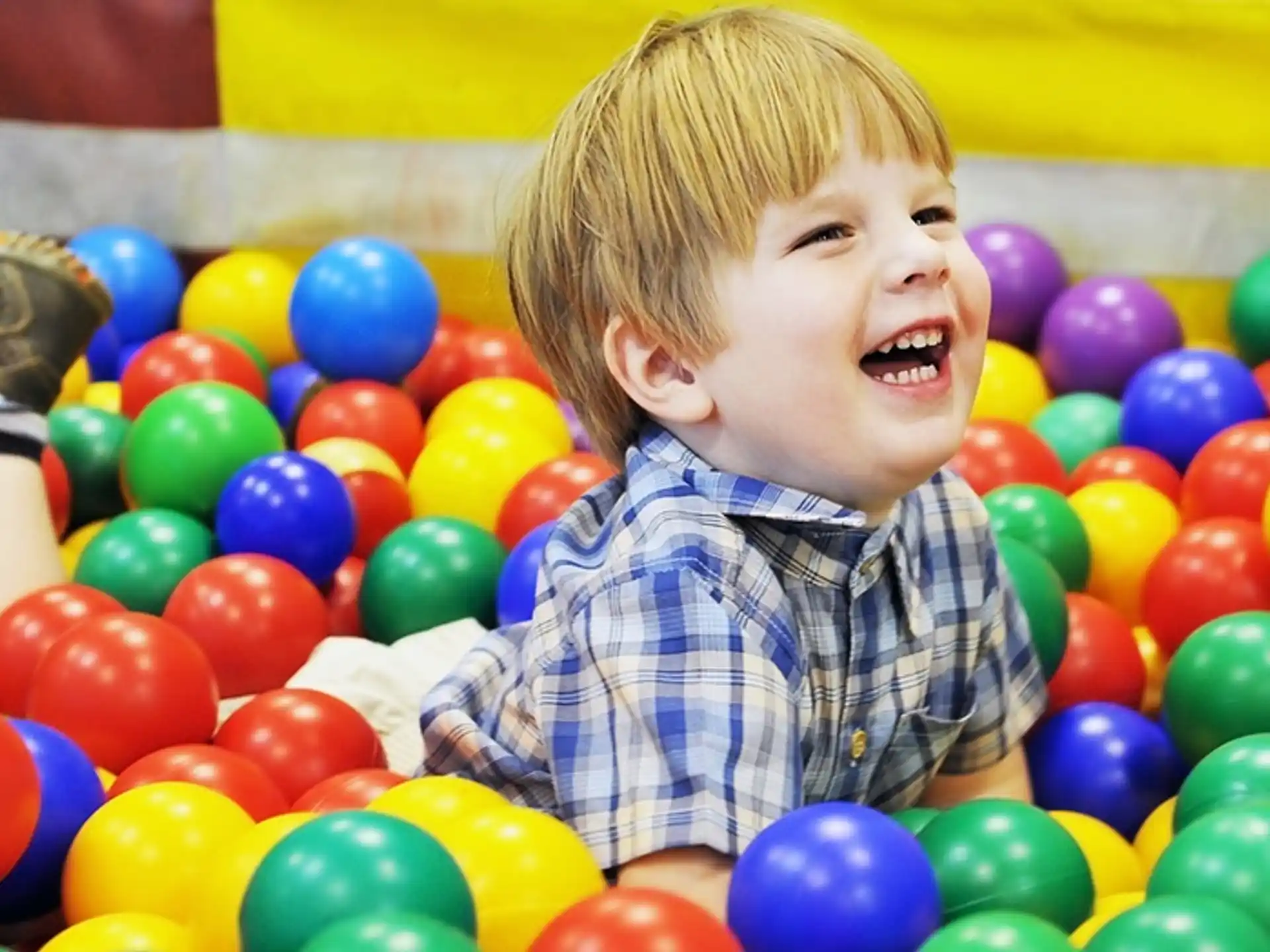 a boy in a ball pit