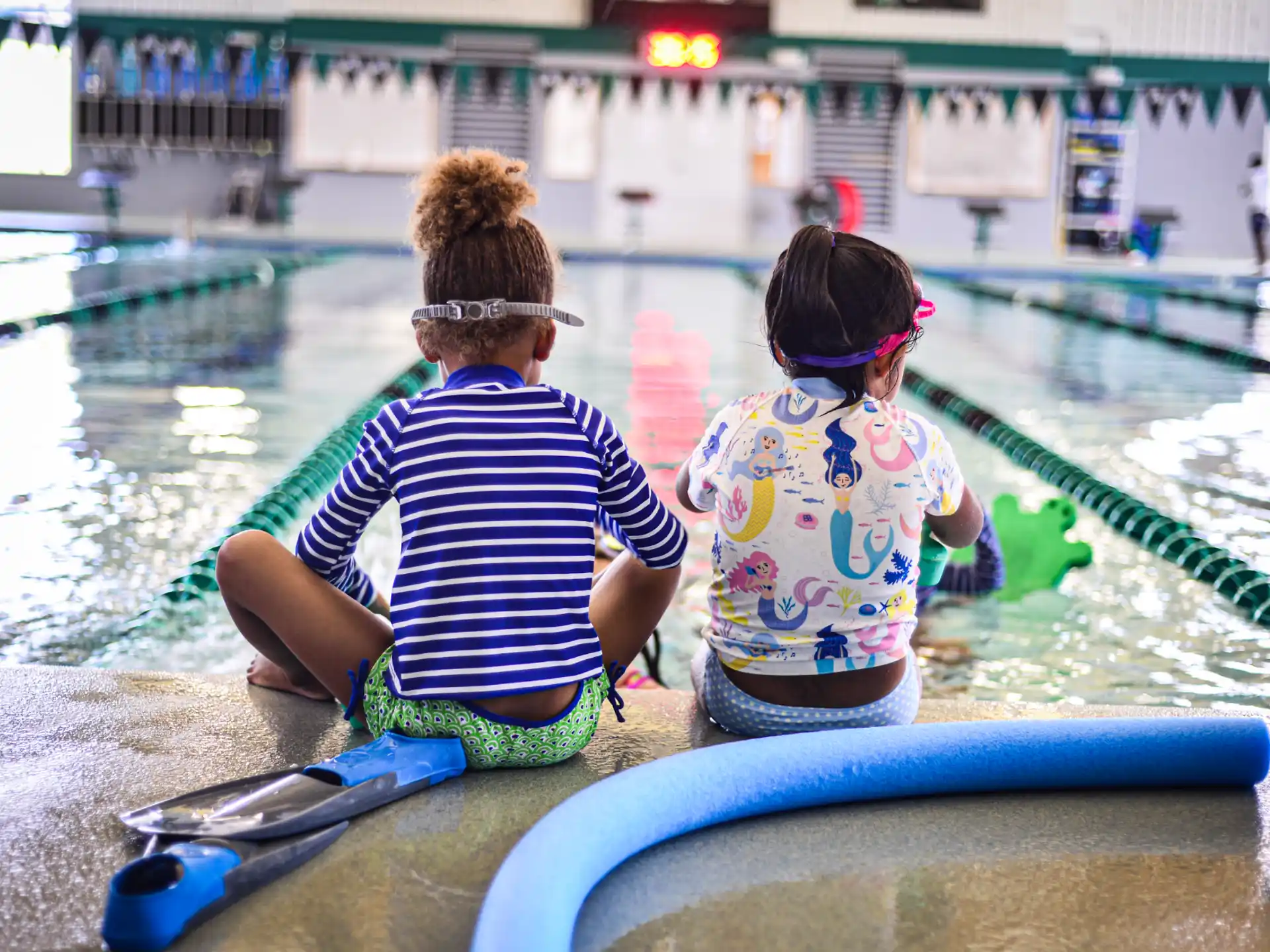 a couple of children sitting in a pool