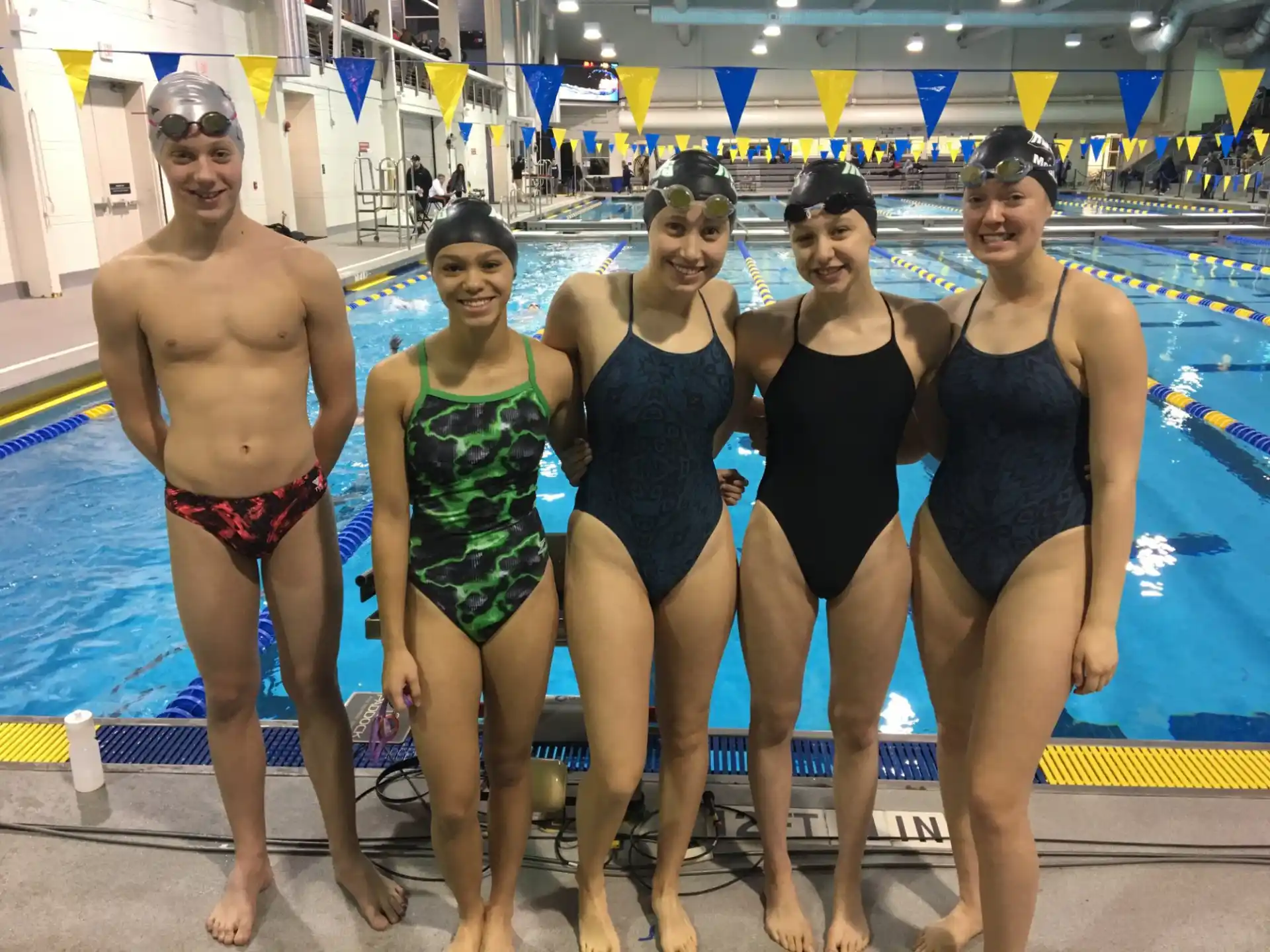 a group of people posing for a photo in front of a swimming pool