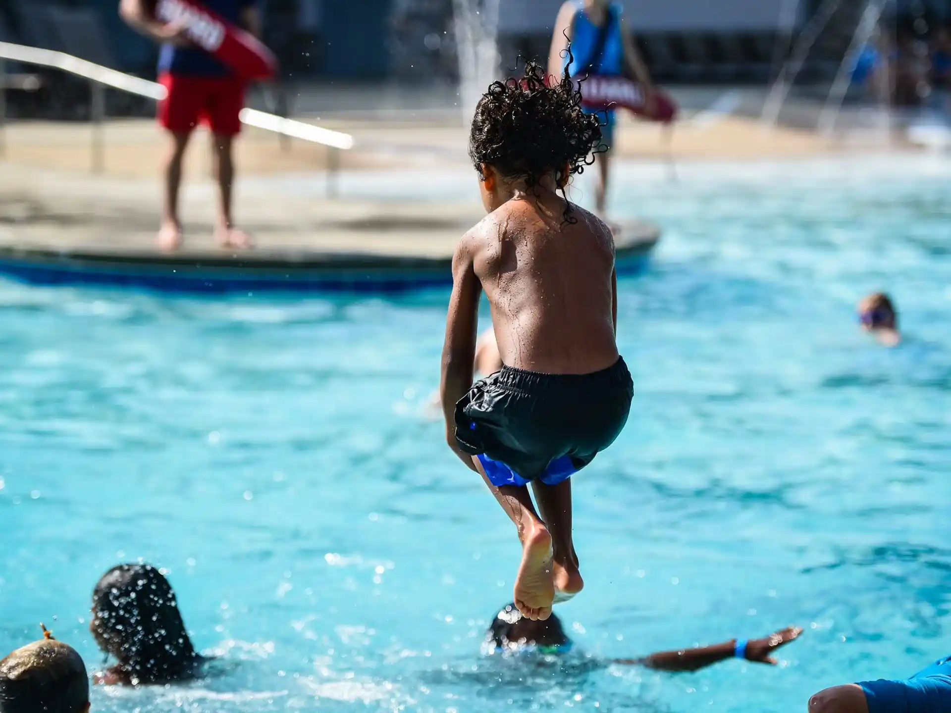 a person in a swimsuit jumping into a pool