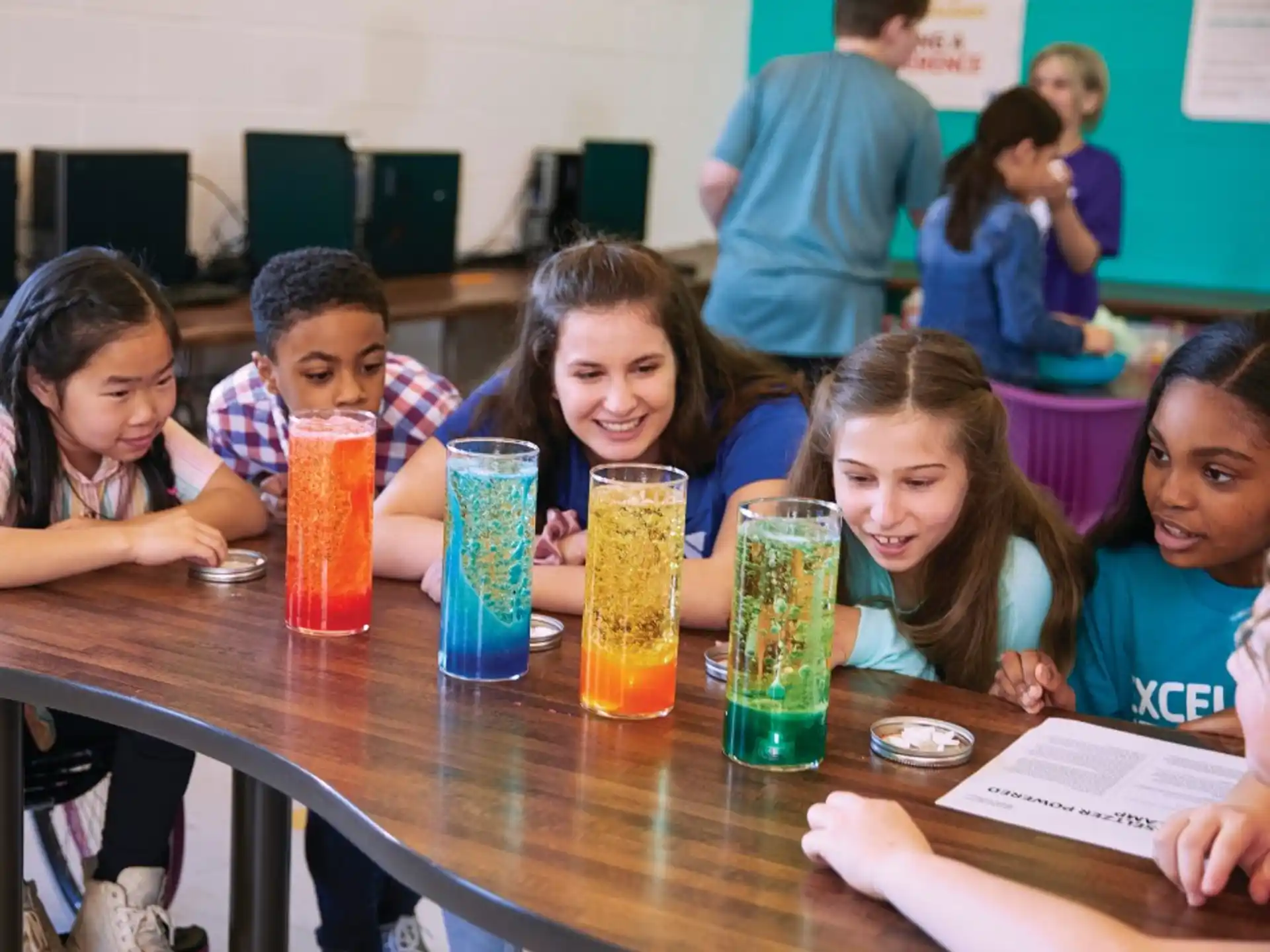 a group of children sitting at a table with drinks
