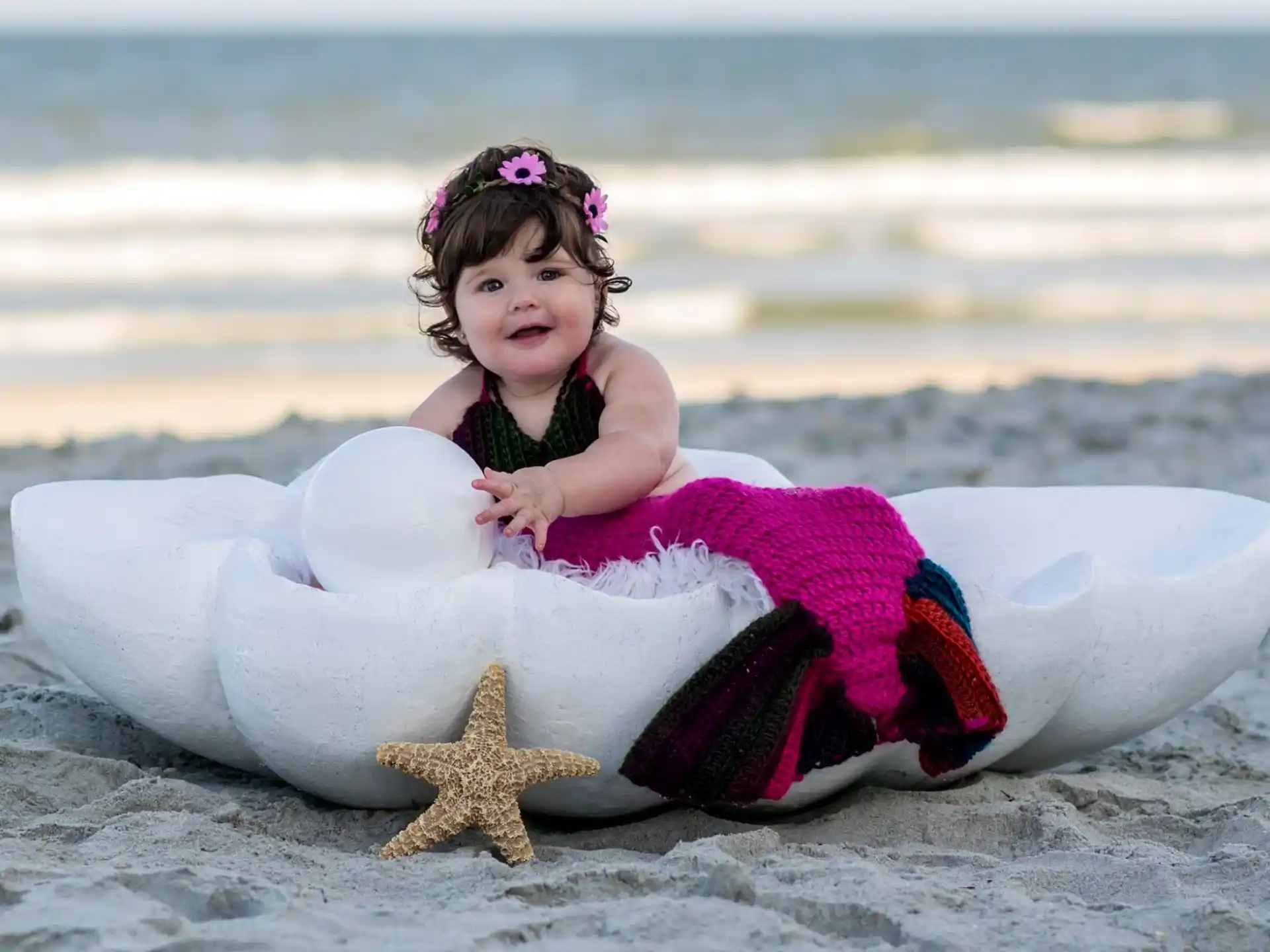 a girl in a dress in a tub on a beach