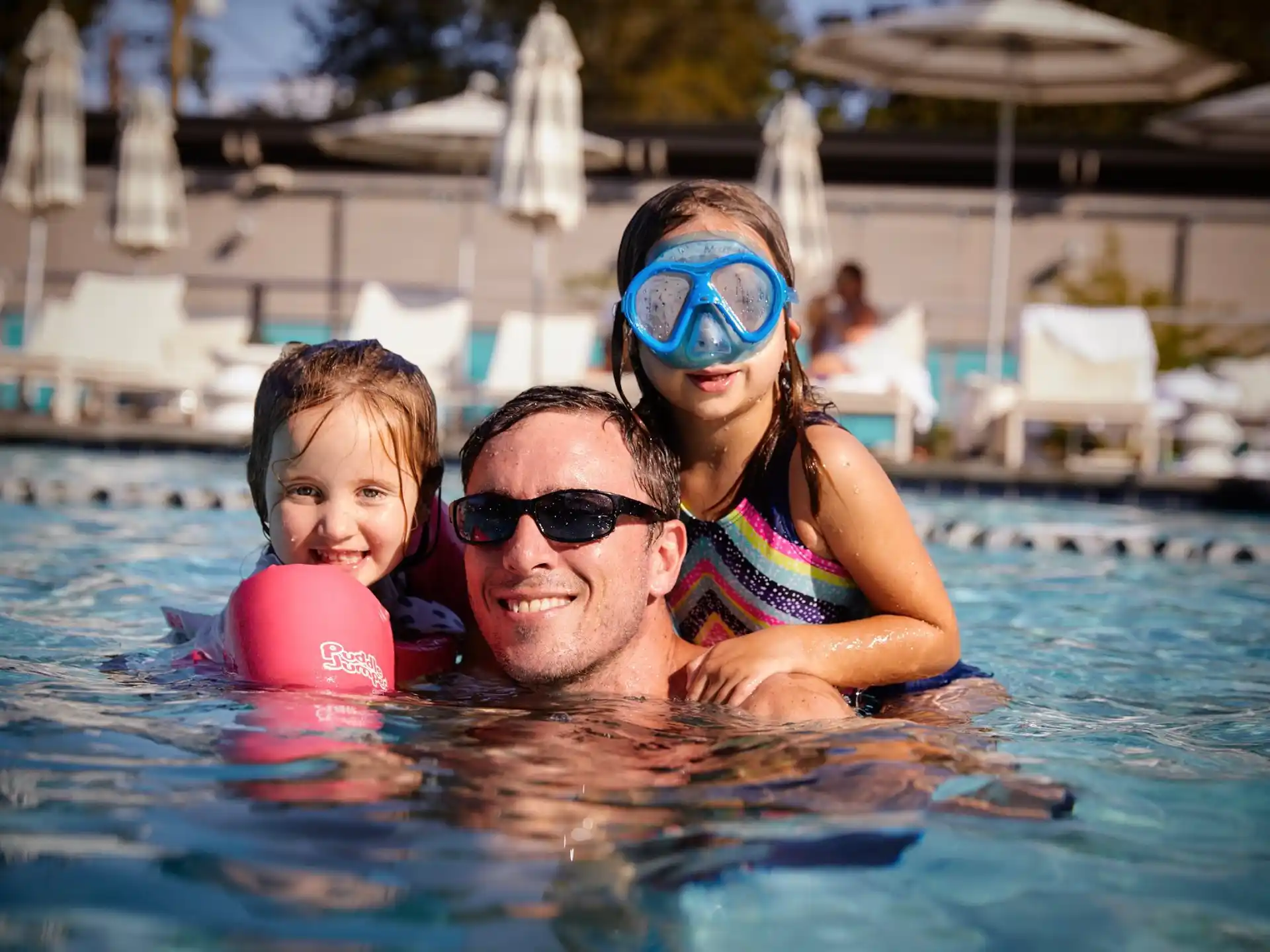 a man and two girls in a pool