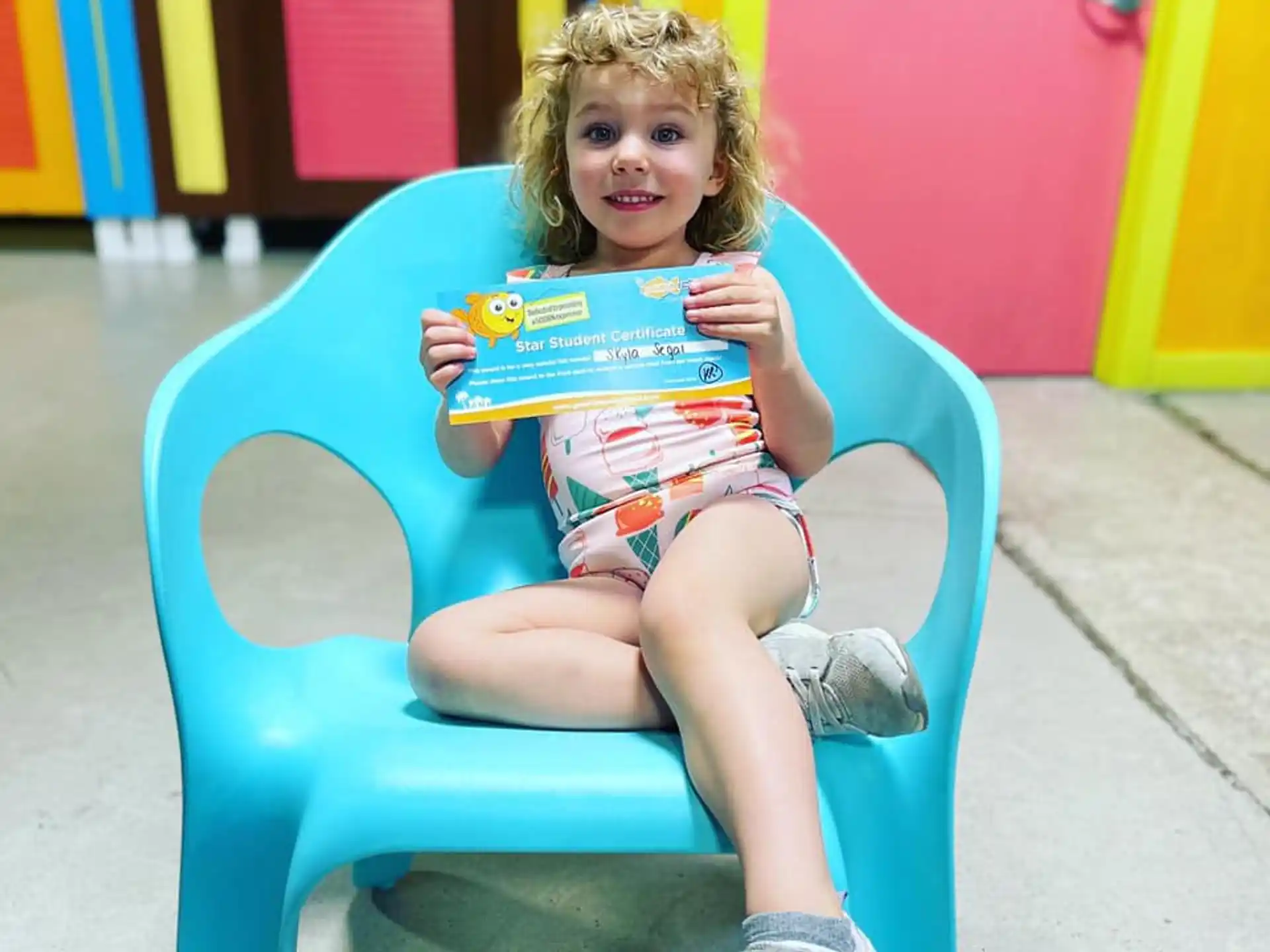 a girl sitting in a chair reading a book