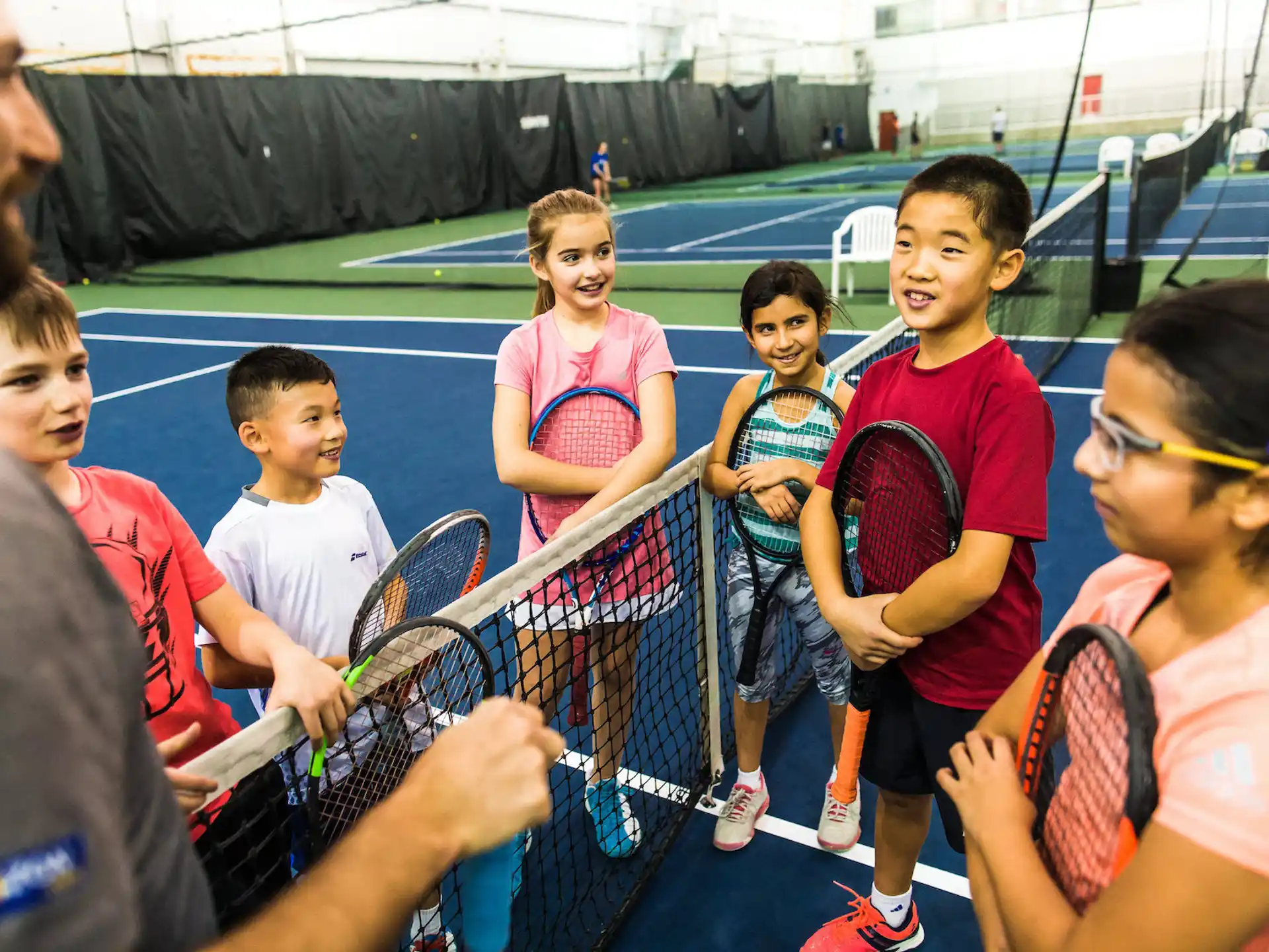 a group of kids holding tennis rackets