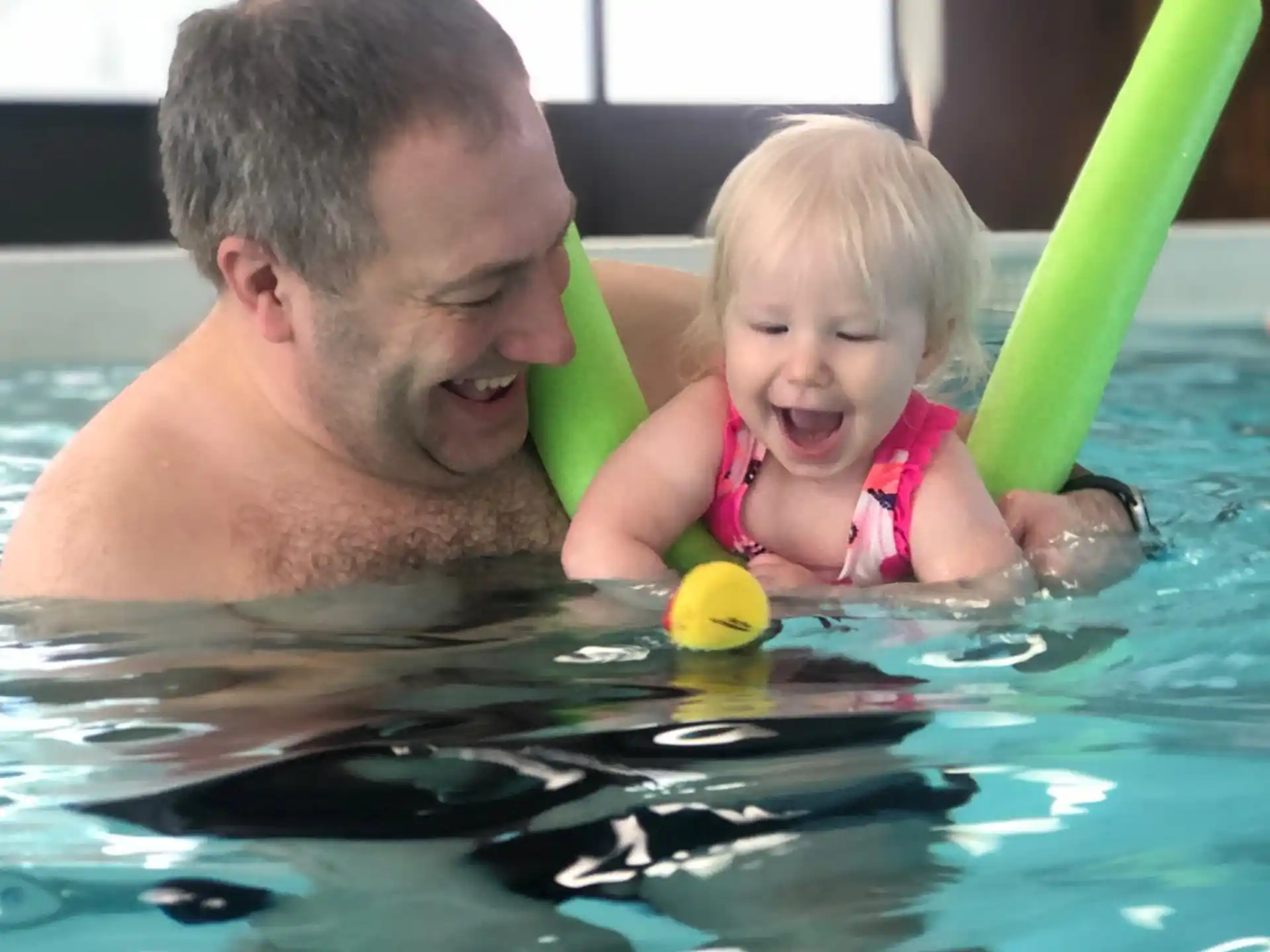 a person and a baby in a pool
